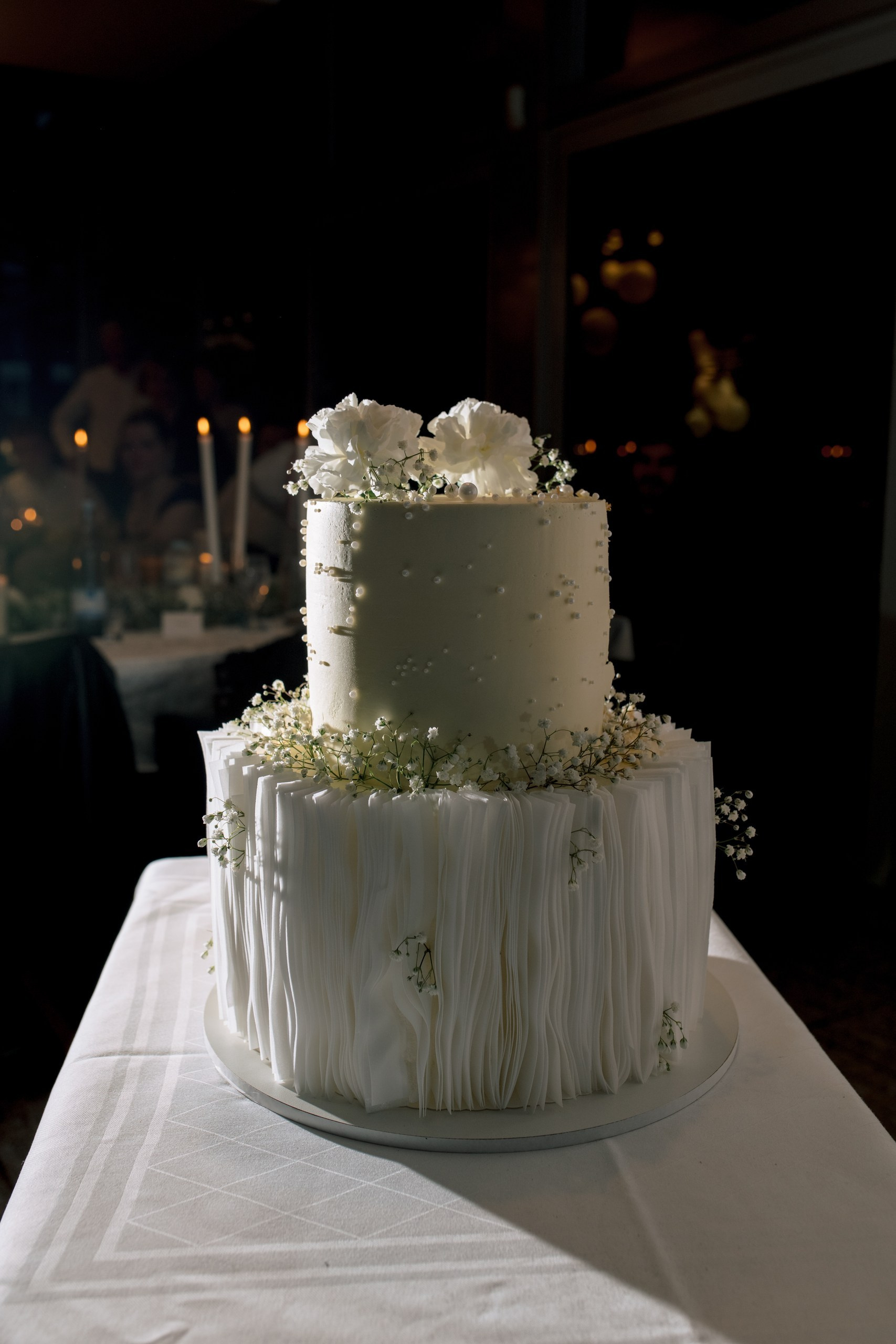 Detailaufnahme der dreistöckigen Hochzeitstorte mit floraler Dekoration