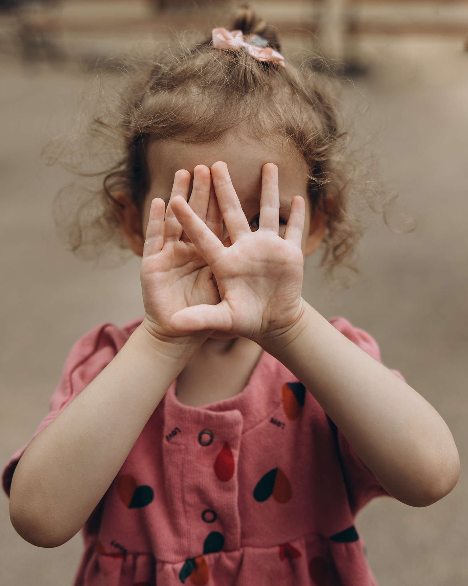 small girl plays peek a boo