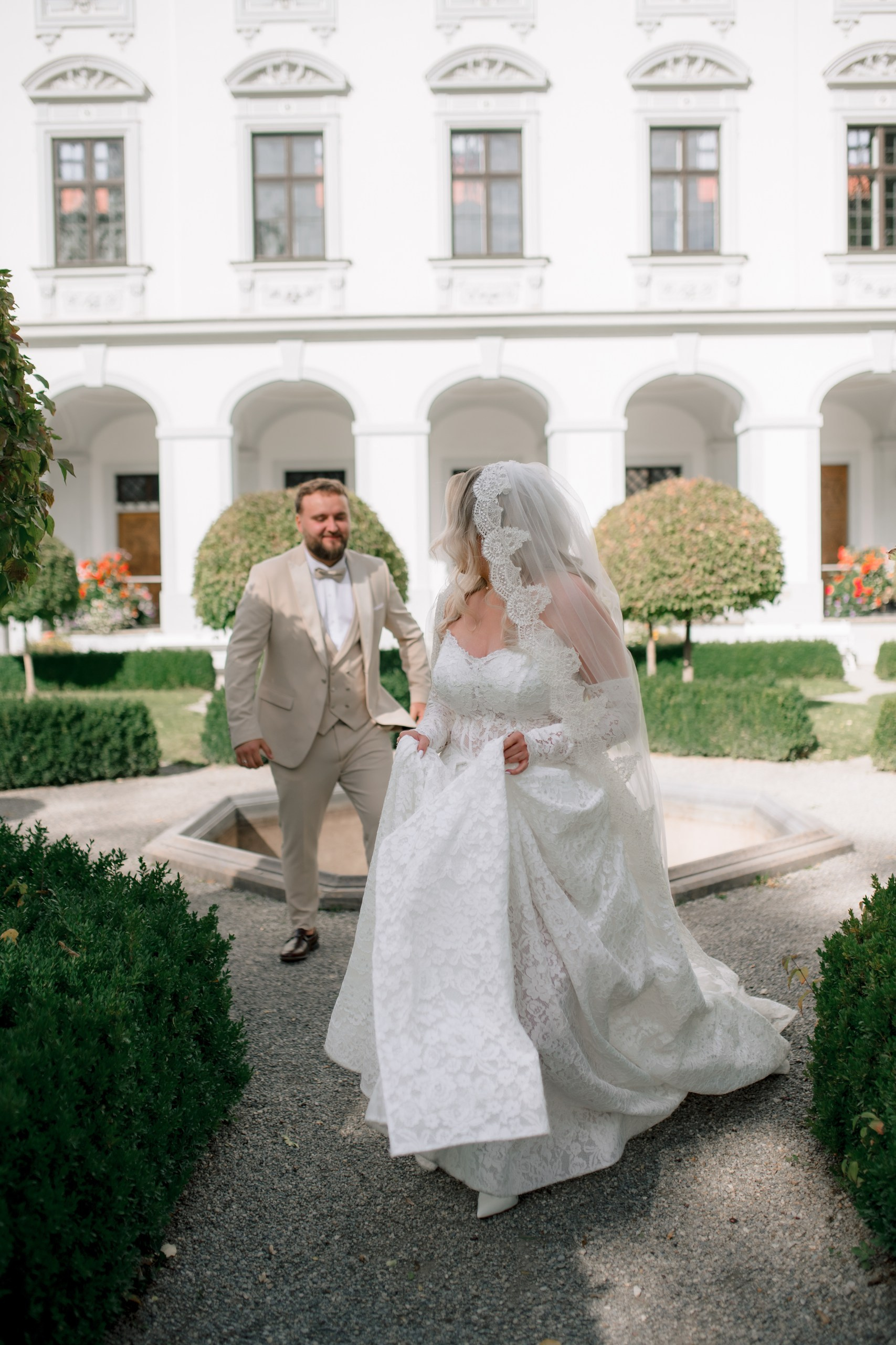 Bräutigam küsst Hand der Braut – elegante Hochzeitsaufnahme