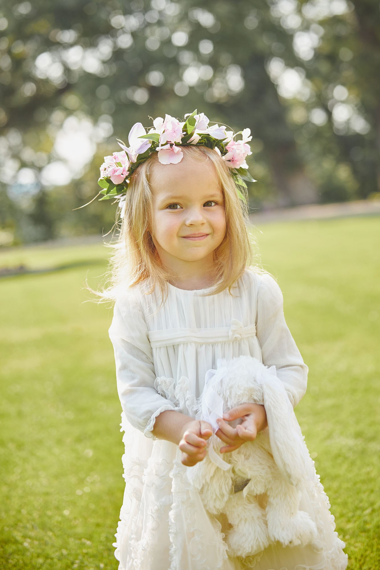 Blonde, blue-eyed flower girl with stuffed animal at Chateau Mcely wedding.