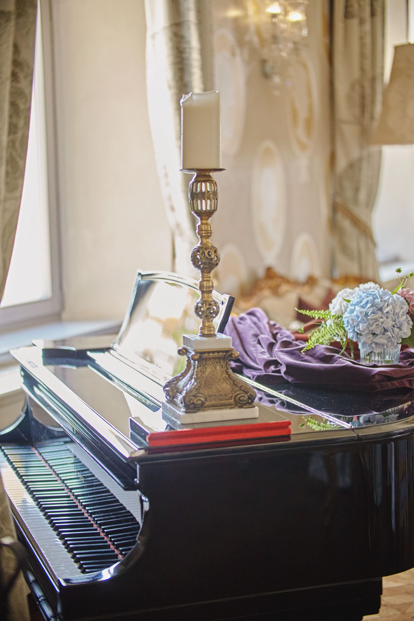 Piano adorned with candelabra and flowers in the historic Chateau Mcely's main dining room.