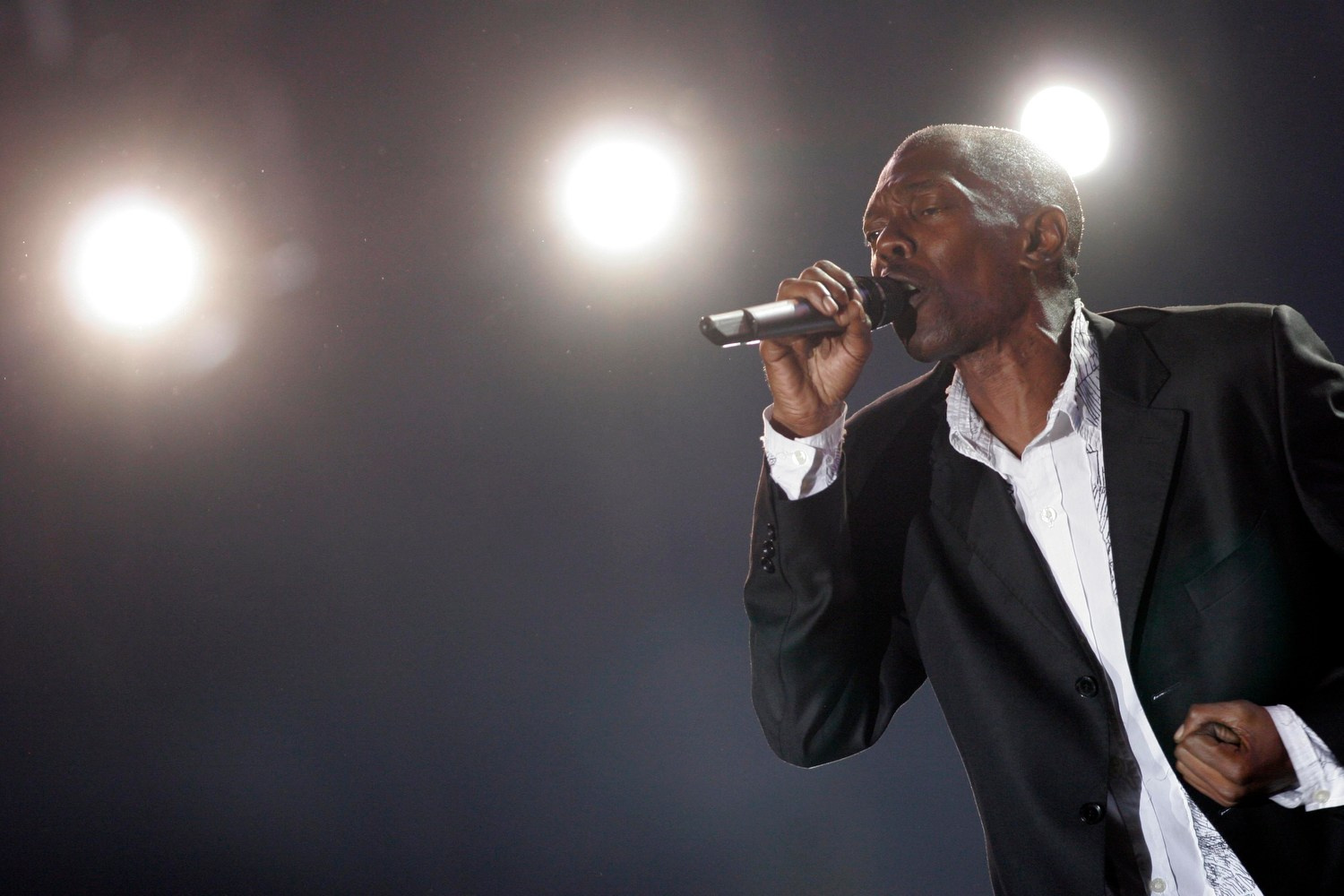 Close-up of Maxi Jazz mid-verse, sweat and passion visible under stage lights.