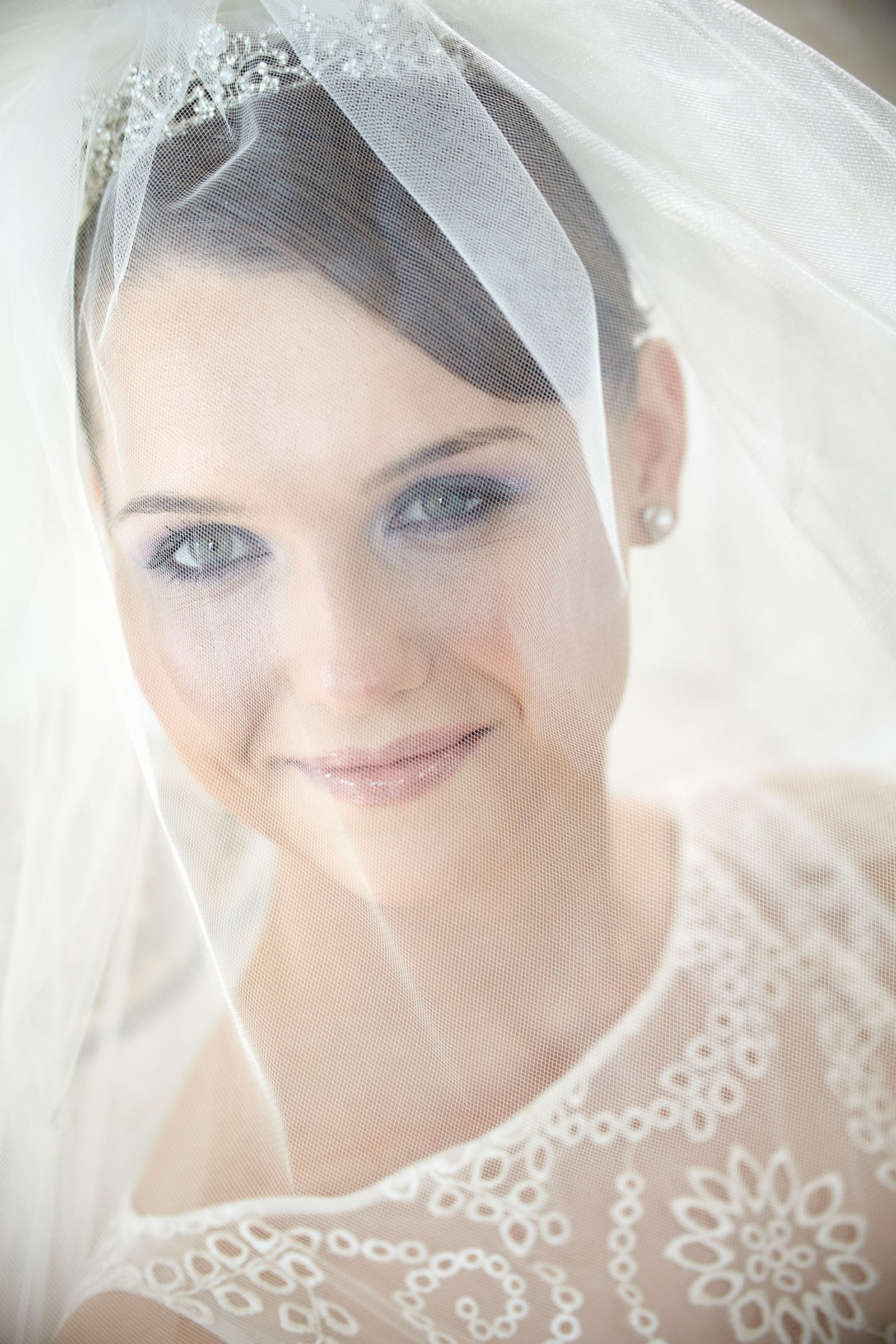 Stunning bridal portrait of young woman under the veil taken post-preparation at Chateau Mcely.