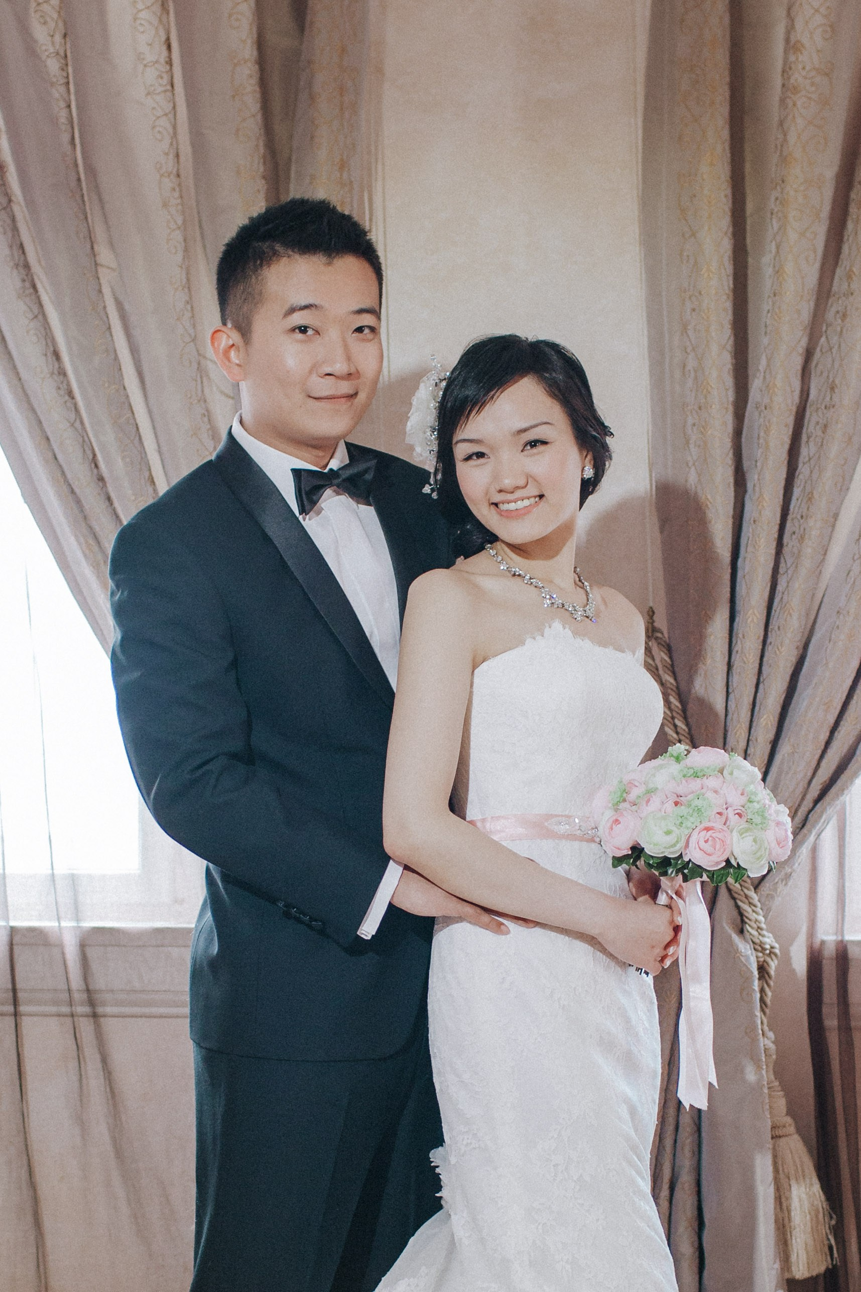 With the old-world charm of their luxury suite providing the ambience, a Hong Kong bride & groom pose for a classical wedding portrait.