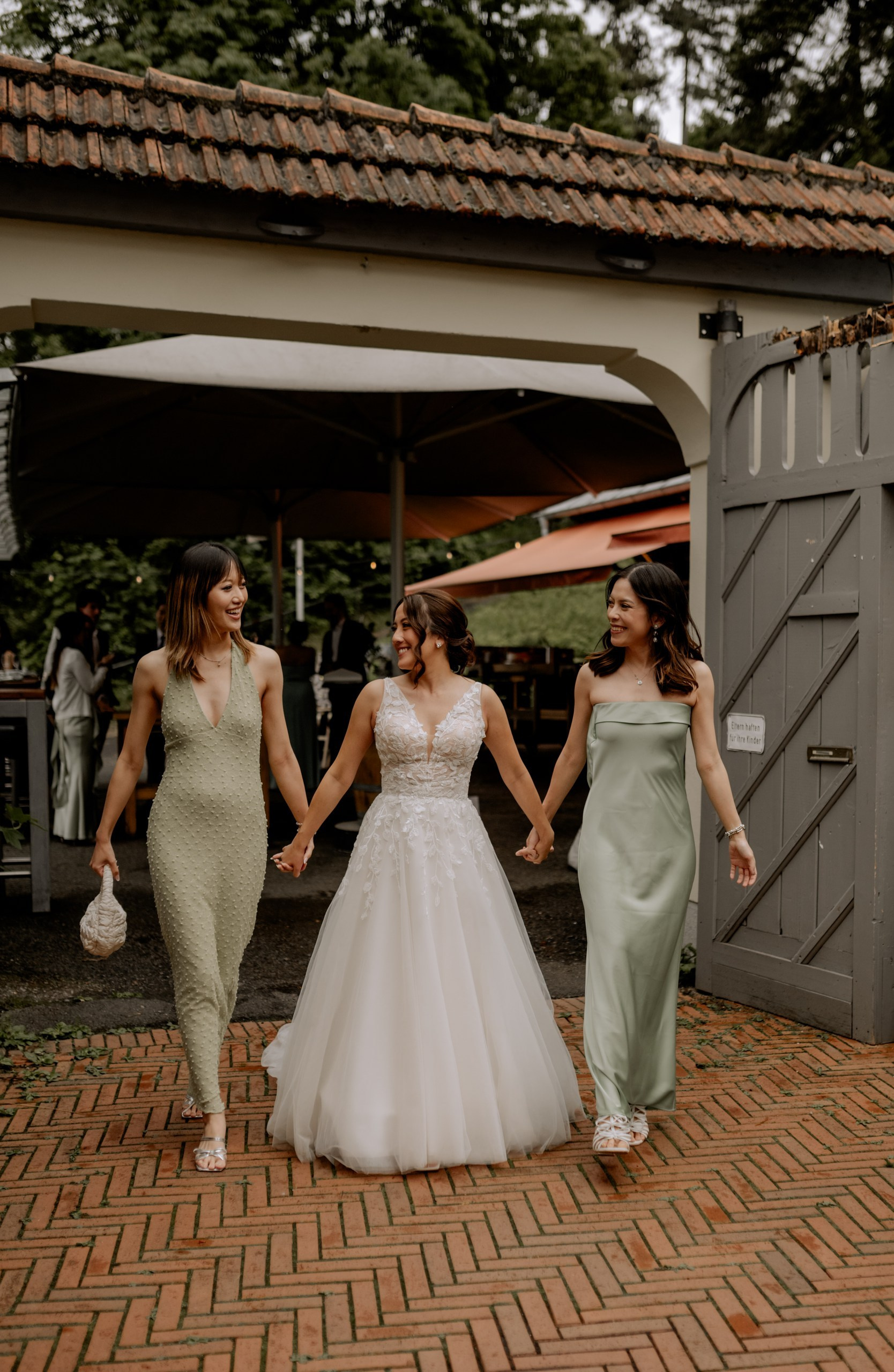 Das Paar spaziert gemeinsam durch den idyllischen Nikolaushof Würzburg. Blumenrabatten und Holzarchitektur bilden eine romantische Kulisse.