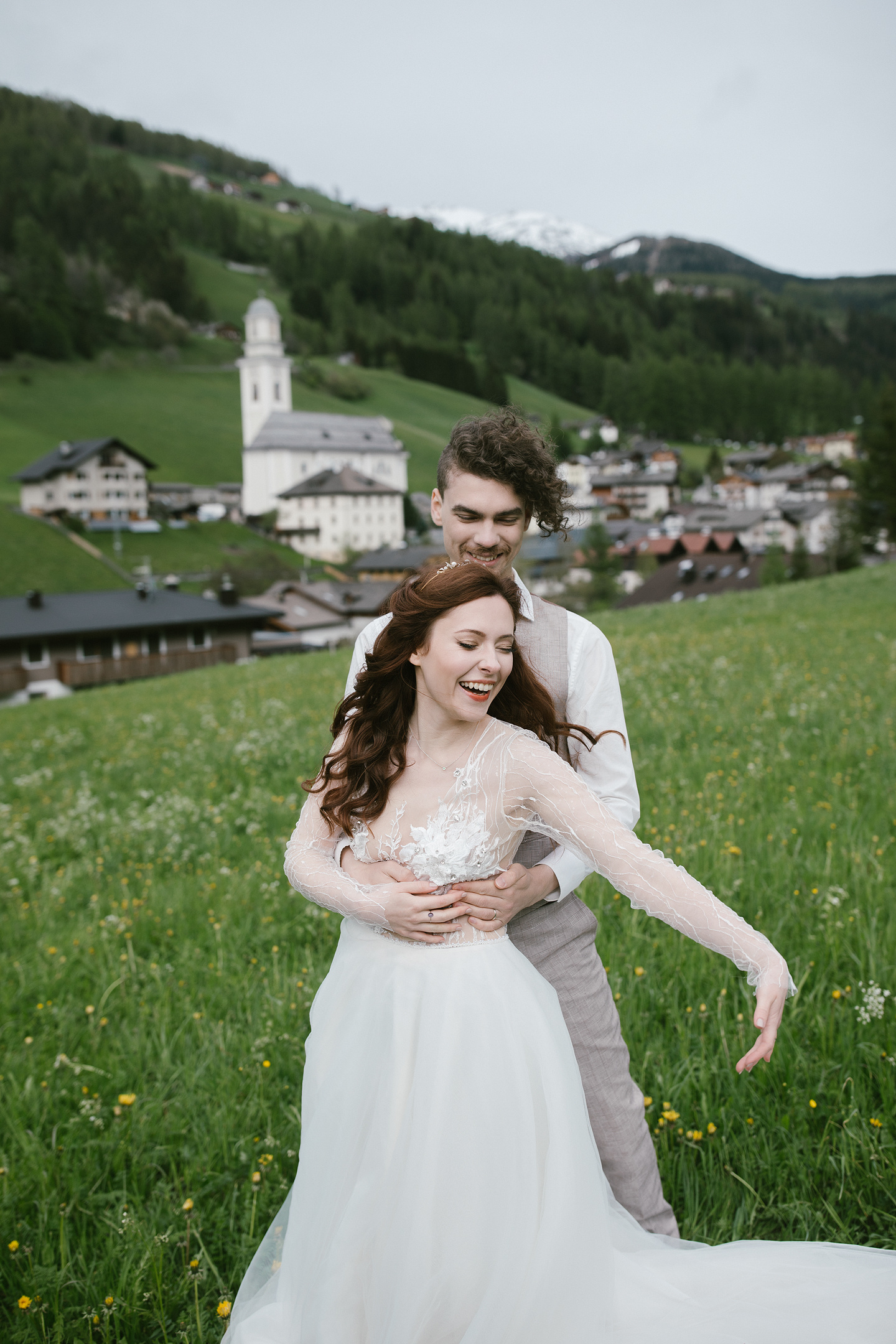 Paar lacht in Dolomitenwiese nach Hochzeit