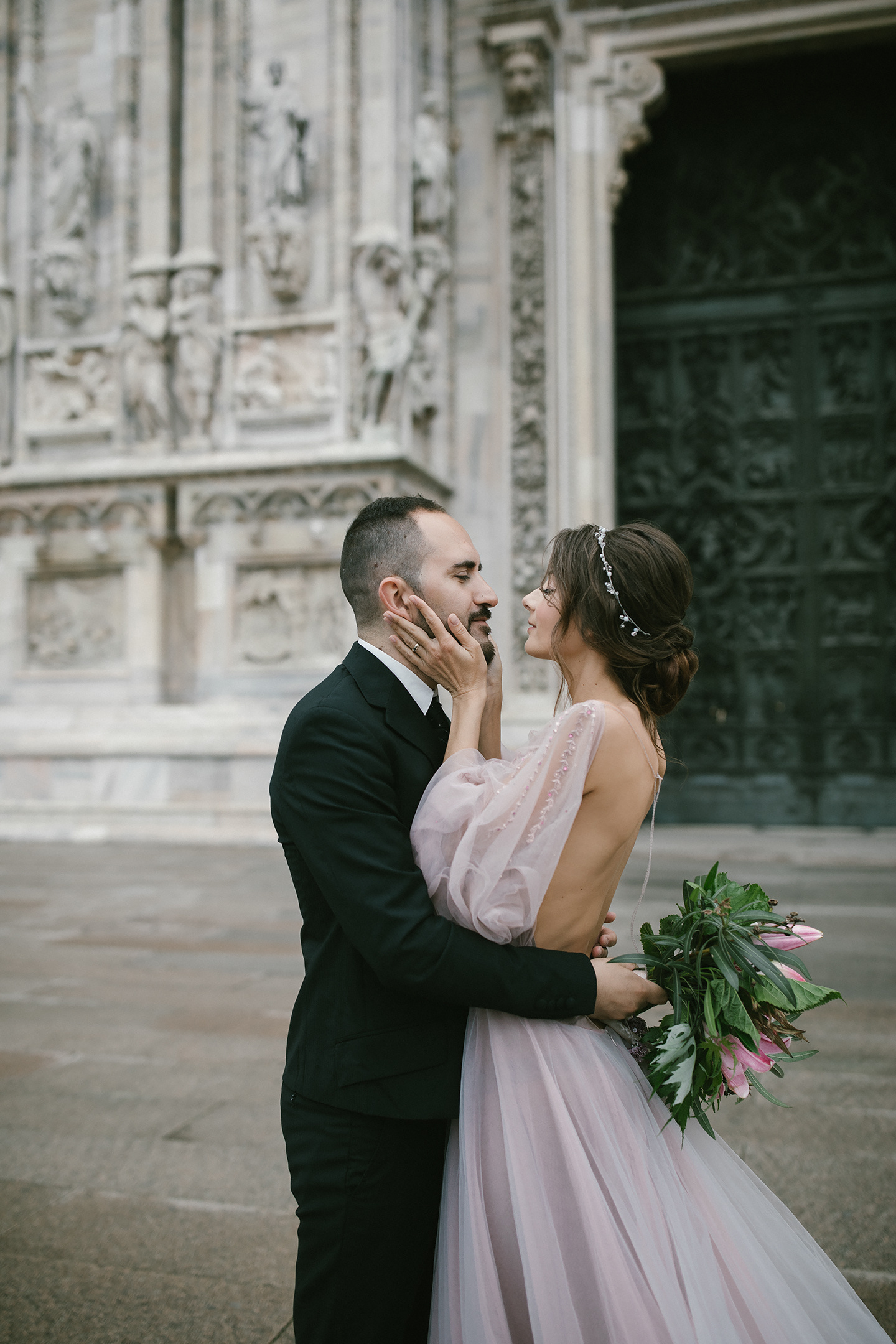 Romantisches Hochzeitspaar umarmt sich vor dem Mailänder Dom