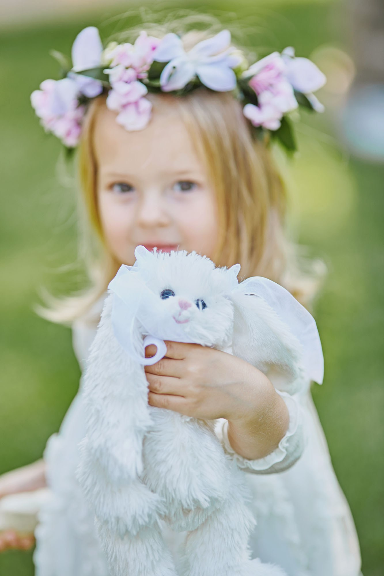 Blonde flower girl with floral headpiece and stuffed toy at Chateau Mcely