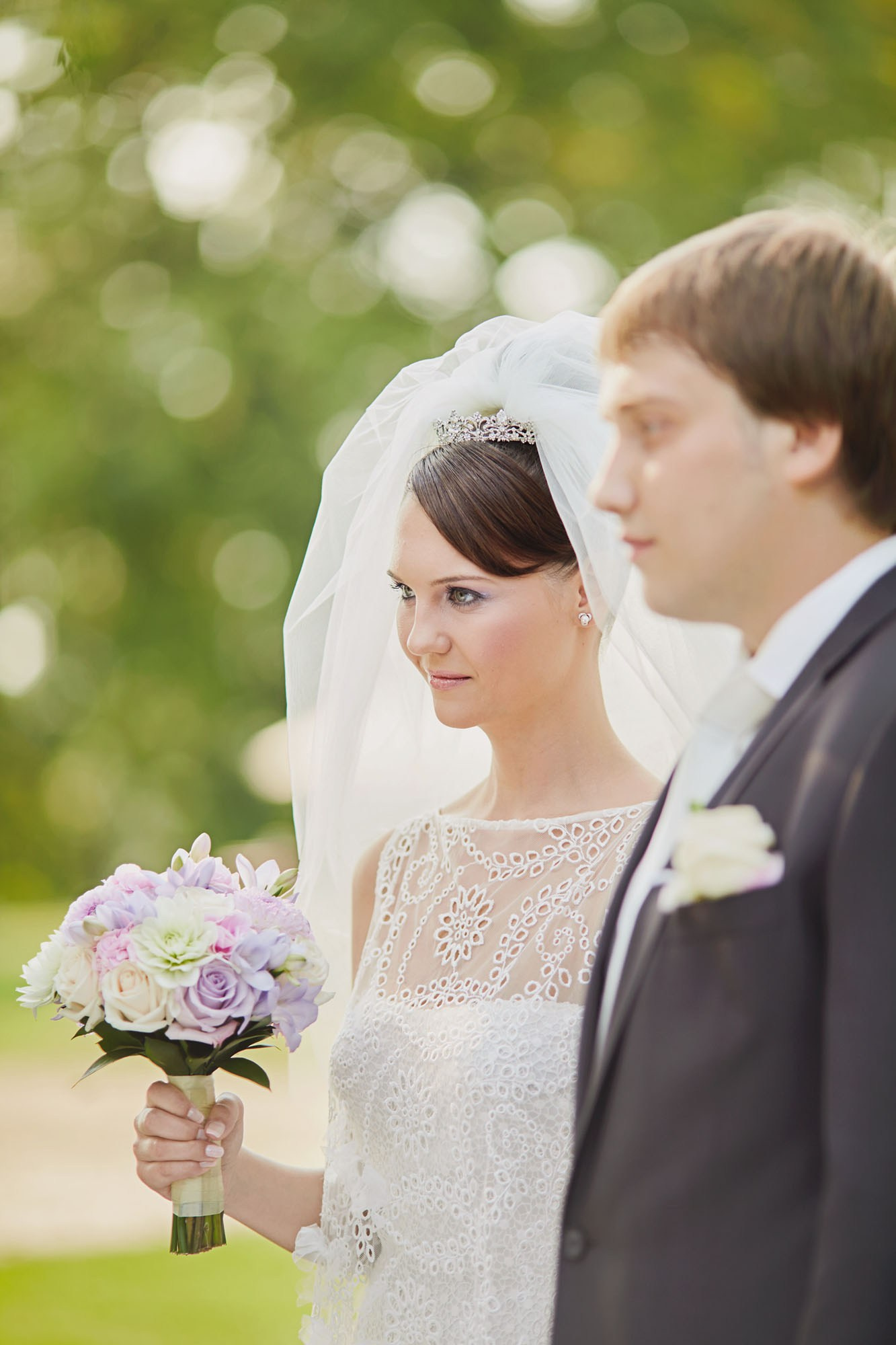Sergey and Ludmila listening to officiants at outdoor chateau wedding in Czechia.