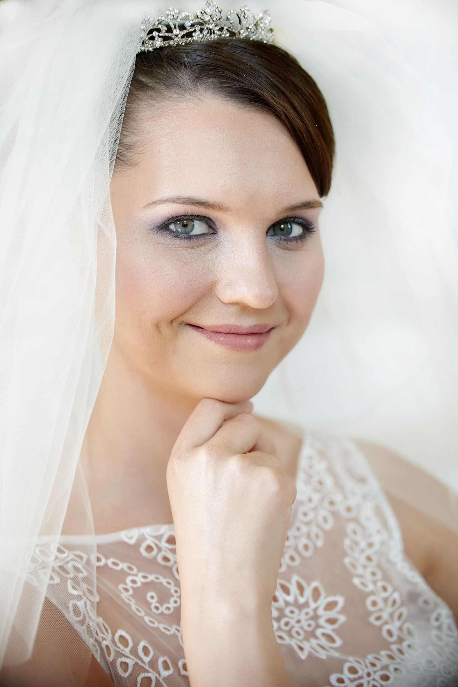 Smiling bride with chin on hand after final bridal prep at Chateau Mcely.