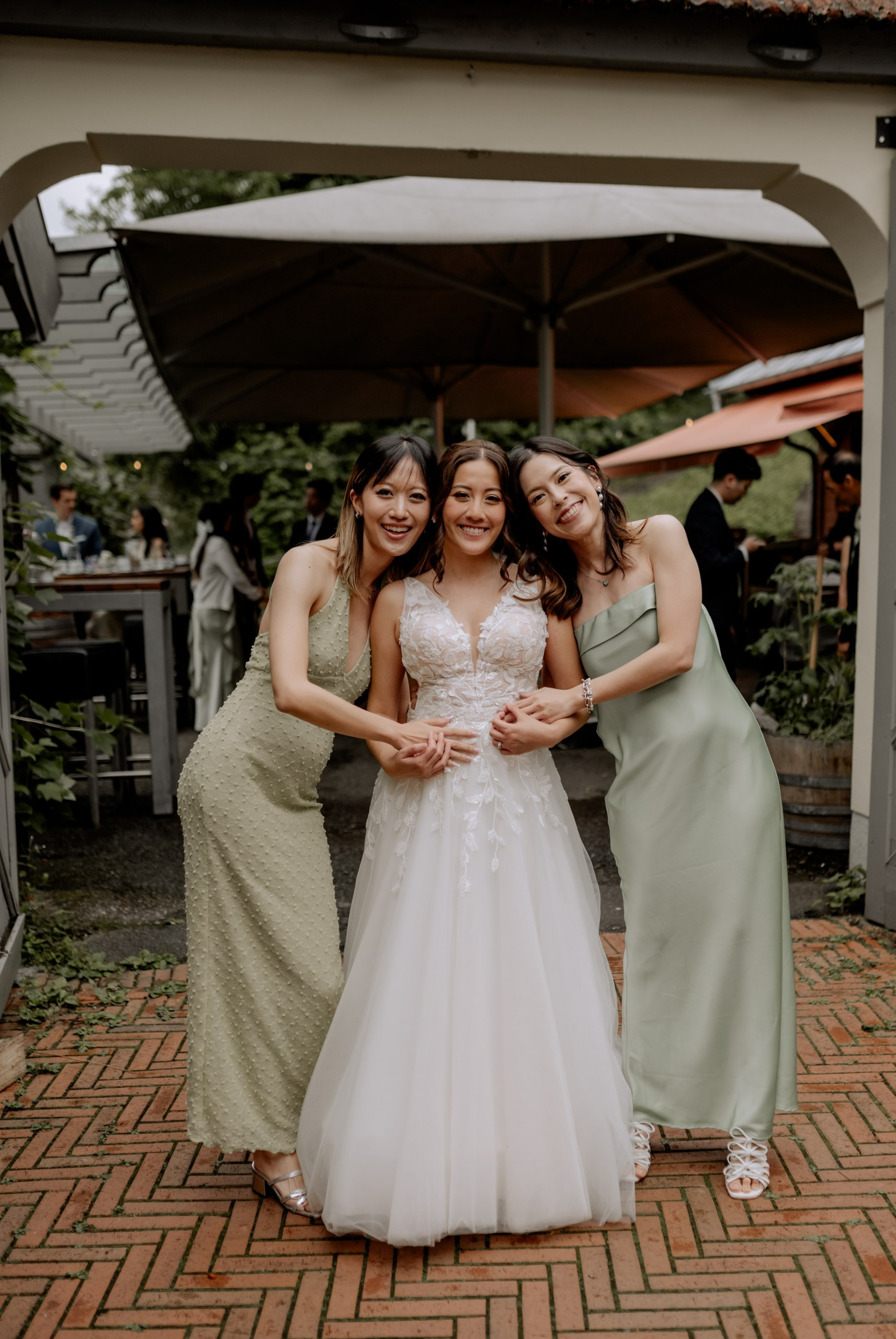 Das Brautpaar steht sich im Hof gegenüber, vermählt unter natürlichem Abendlicht. Holztische, Laternen und grüne Pflanzen rahmen die Szene ein.