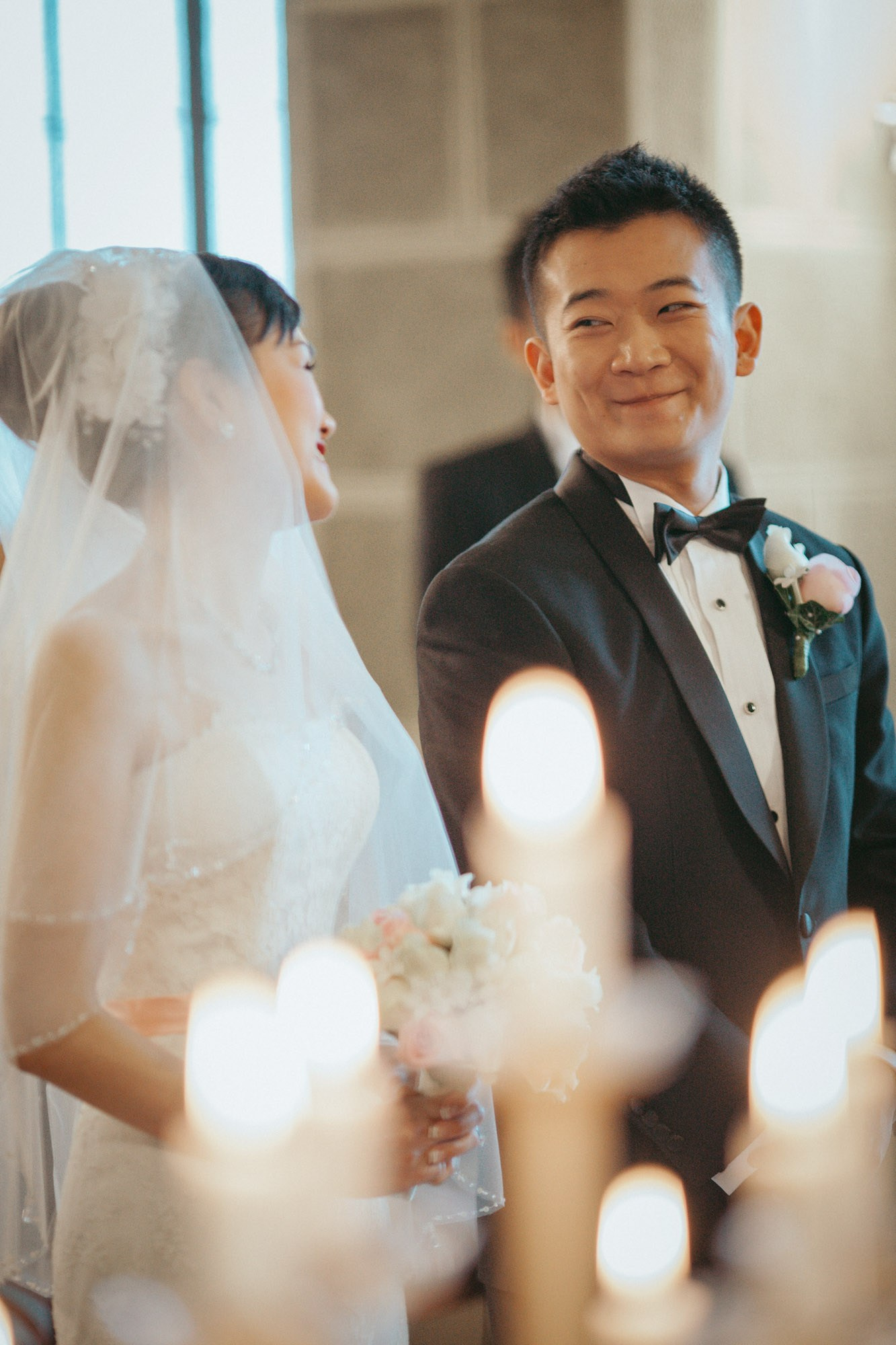 A smiling groom looks towards his beautiful Hong Kong bride during their destination wedding at the historic State Chateau of Hluboka in Czechia.