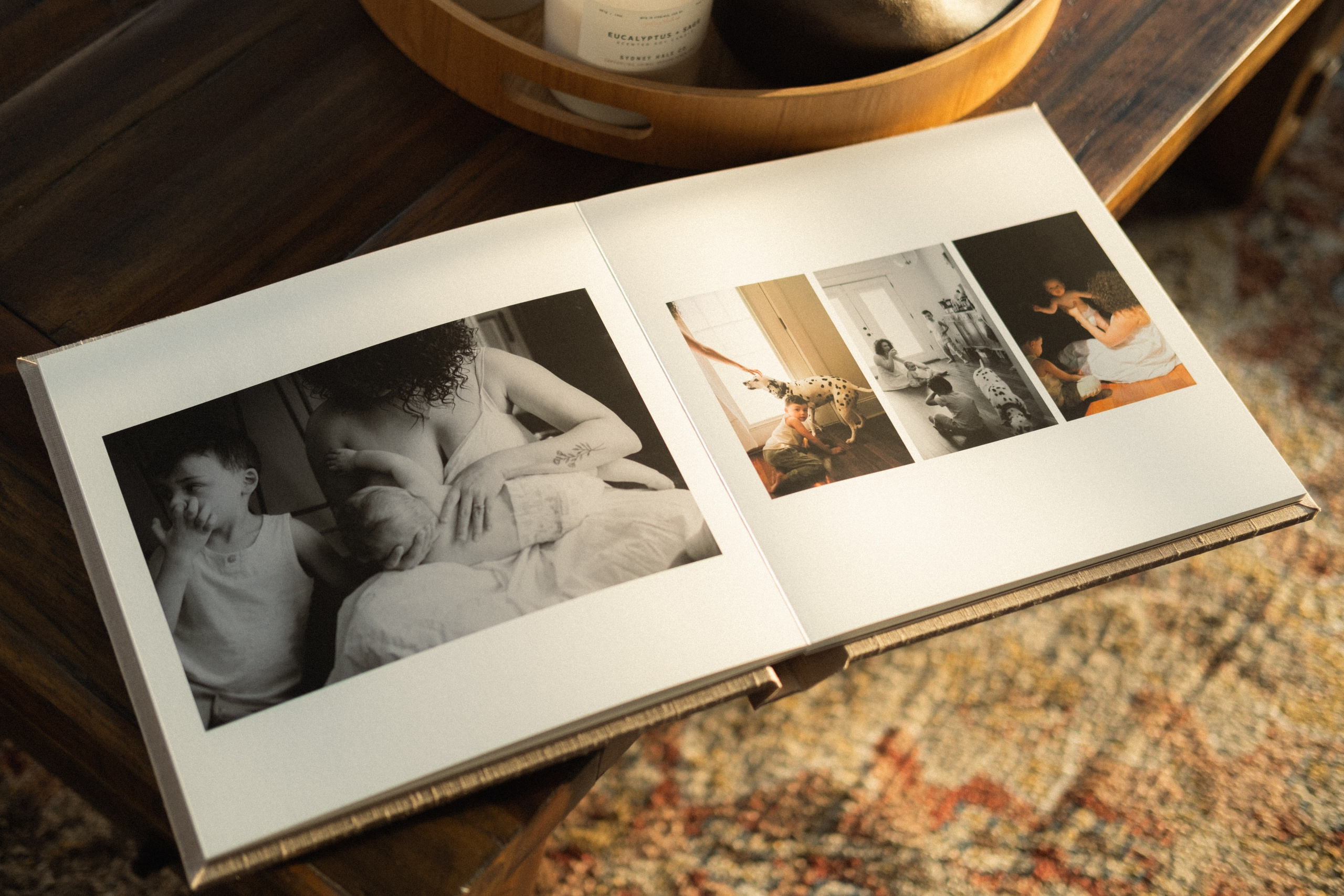 Open family photo album featuring candid moments from an in-home session, professionally designed and printed as a keepsake heirloom
