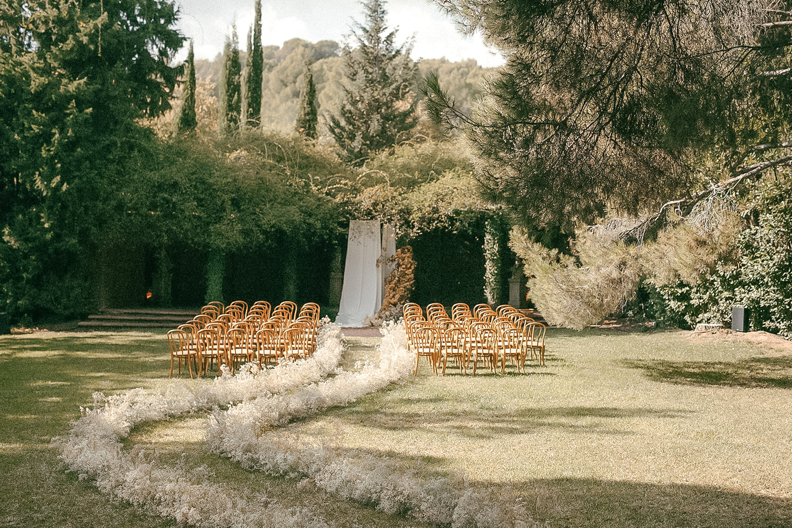 Intimate wedding ceremony setup surrounded by olive trees at La Centenaria 1779, farmhouse venue near Barcelona.