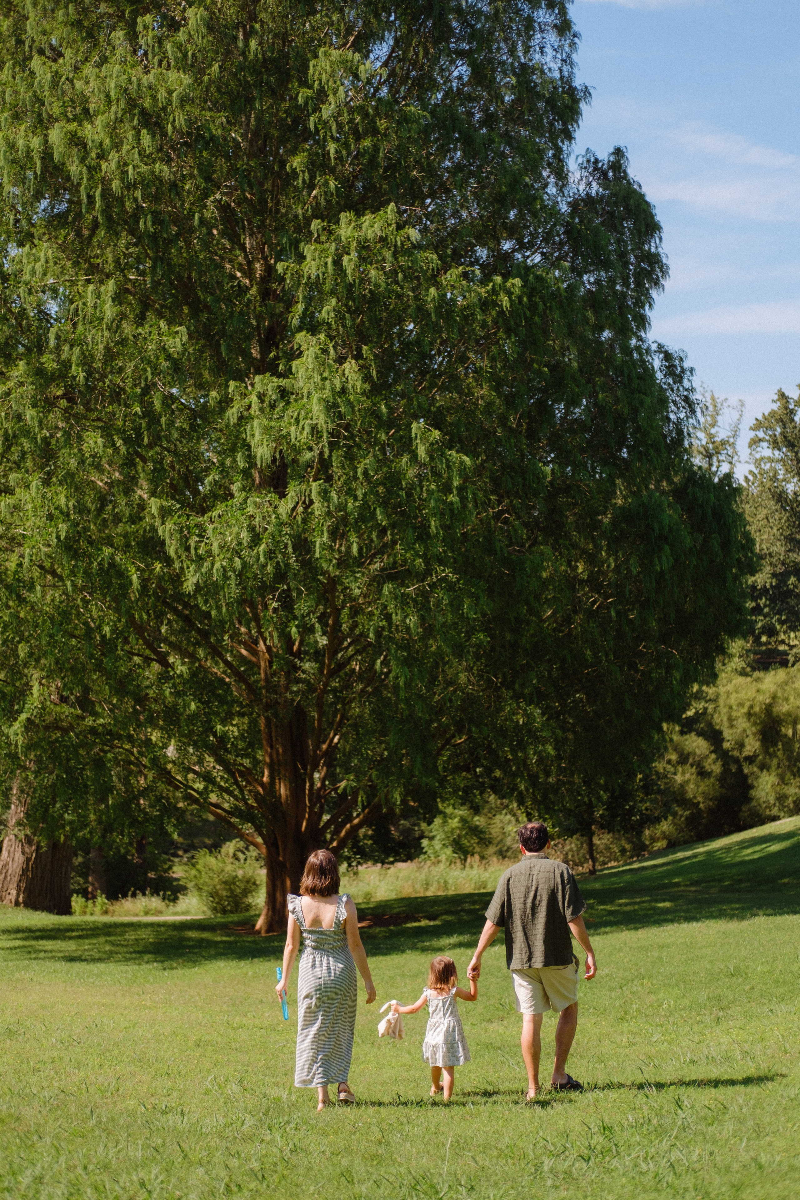 Parents and their little girls are walking hand in hand in Maymont Park in Richmond, VA