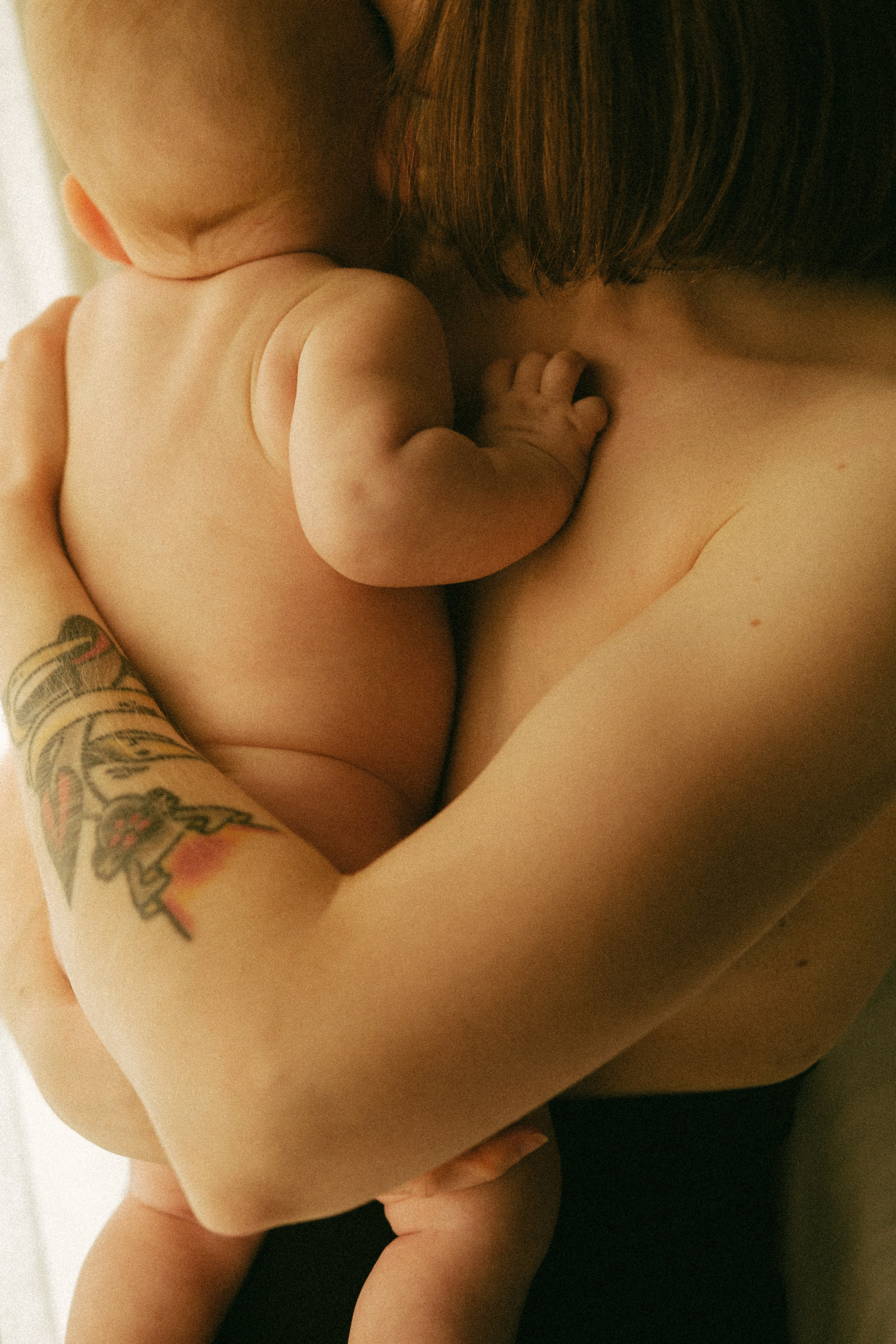 A raw and emotional motherhood portrait that highlights the deep bond between a mother and her baby in a timeless, documentary style.