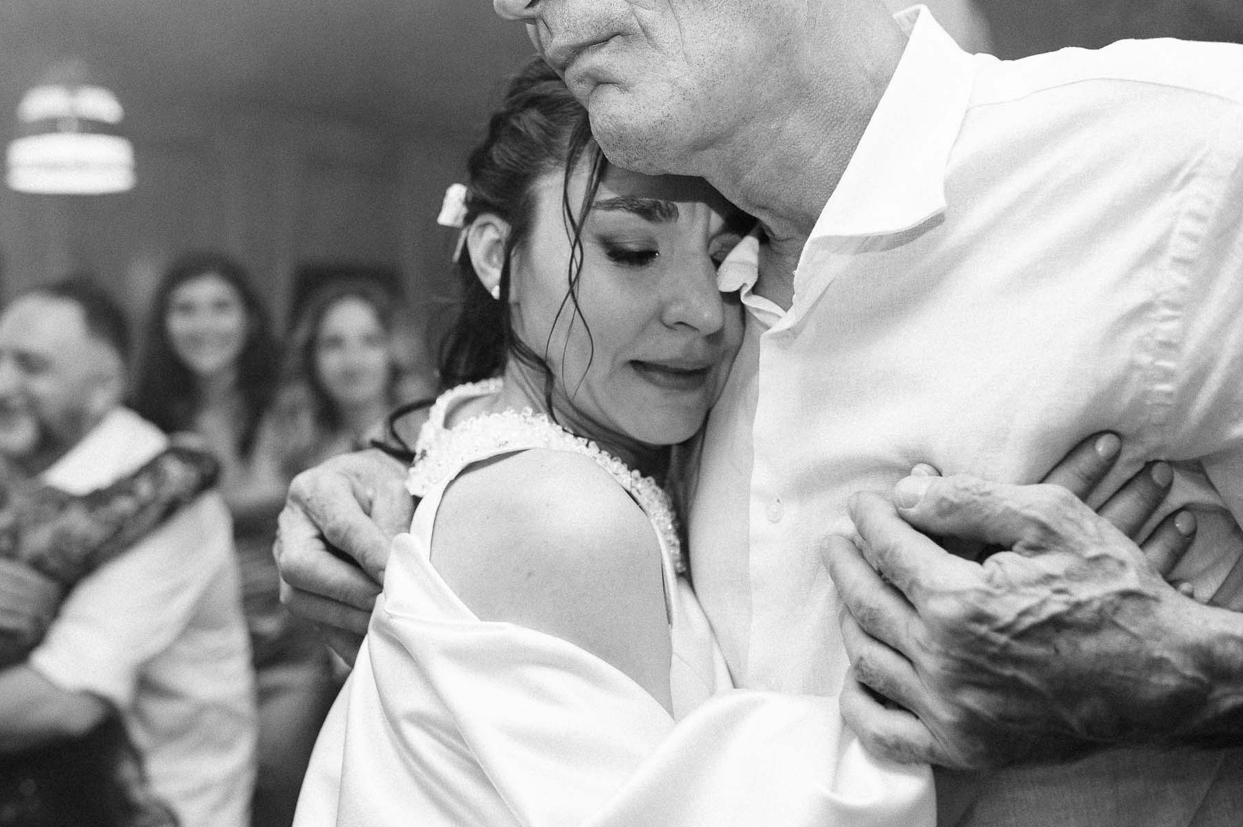 foto matrimonio con un Momento toccante tra la sposa e suo padre in bianco e nero, in un abbraccio profondo ed emozionante, una scena di pura connessione emotiva durante le nozze.