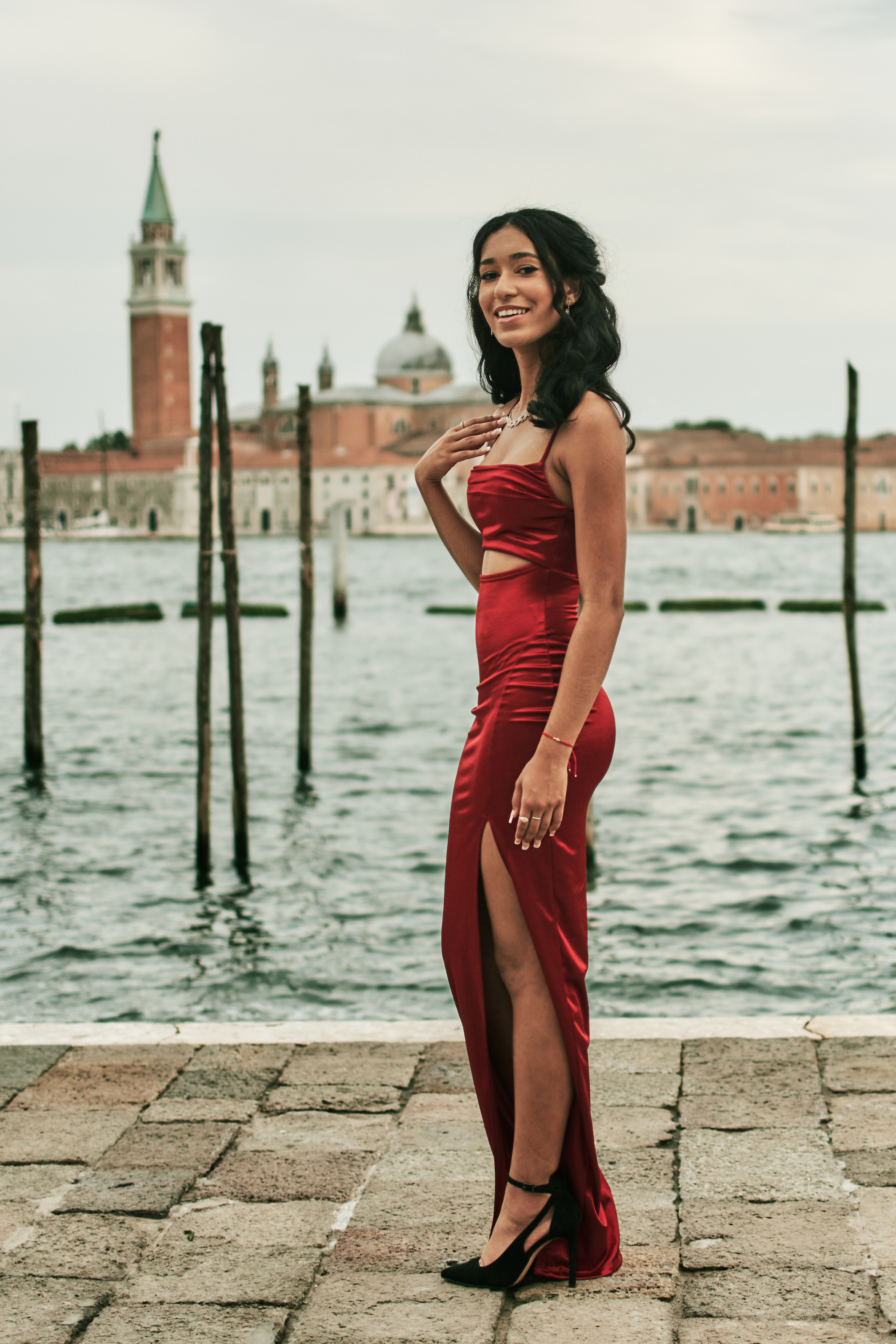 Serene moments captured as a girl in a red dress enjoys a photoshoot in Venice's narrow canals.