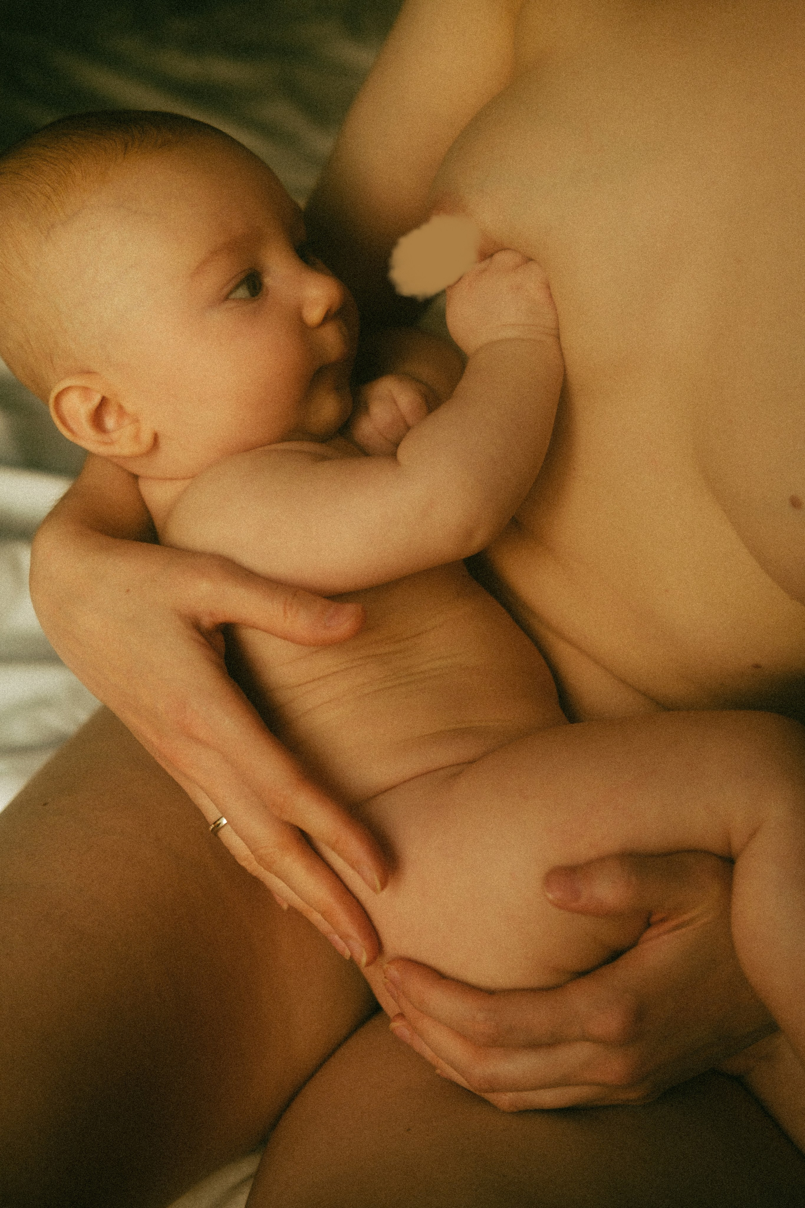 A tender moment between mother and baby, showcasing the raw beauty and deep connection of motherhood through emotive, natural photography.