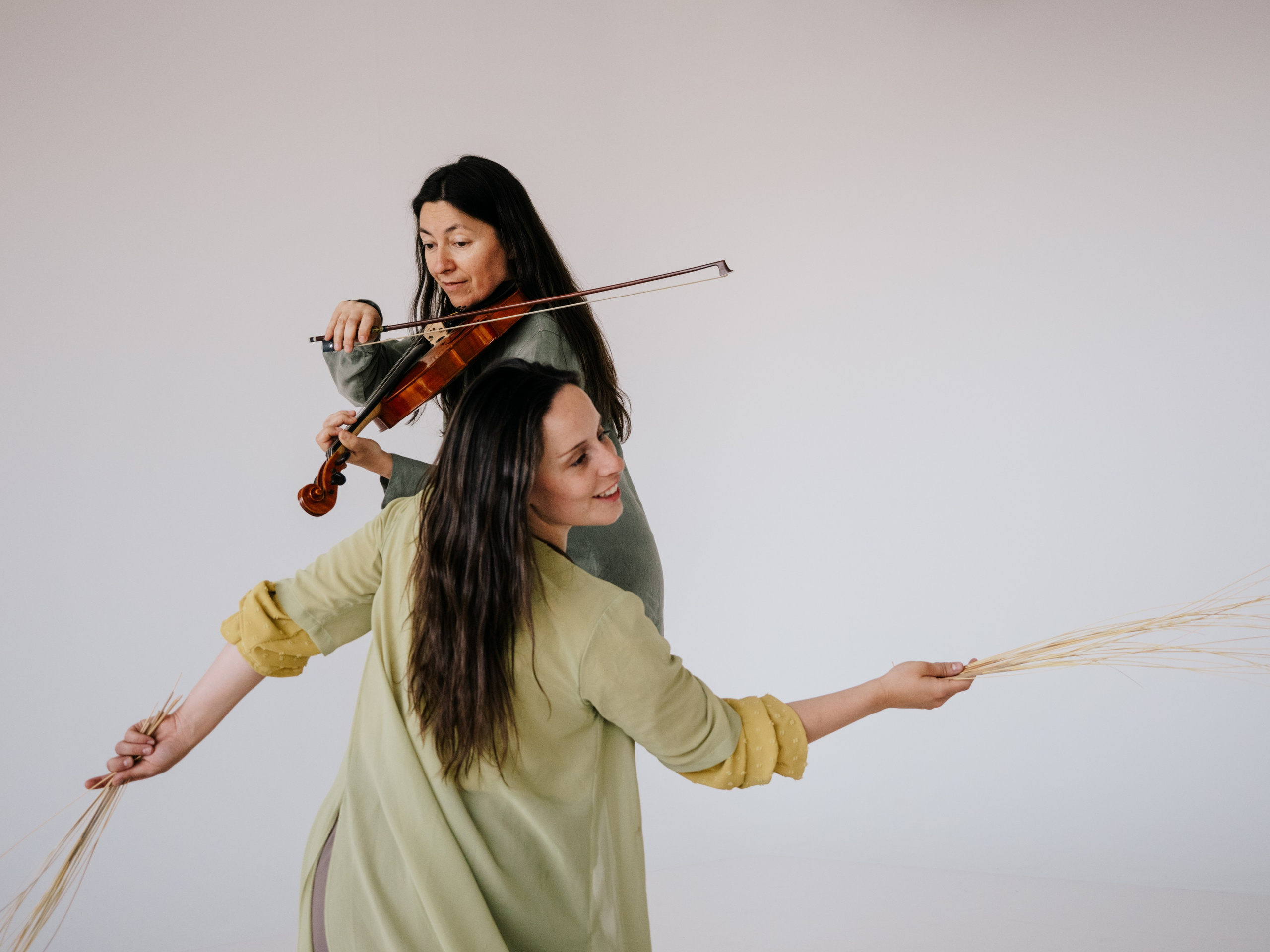 Dancer dancing in front of Musician playing violin.