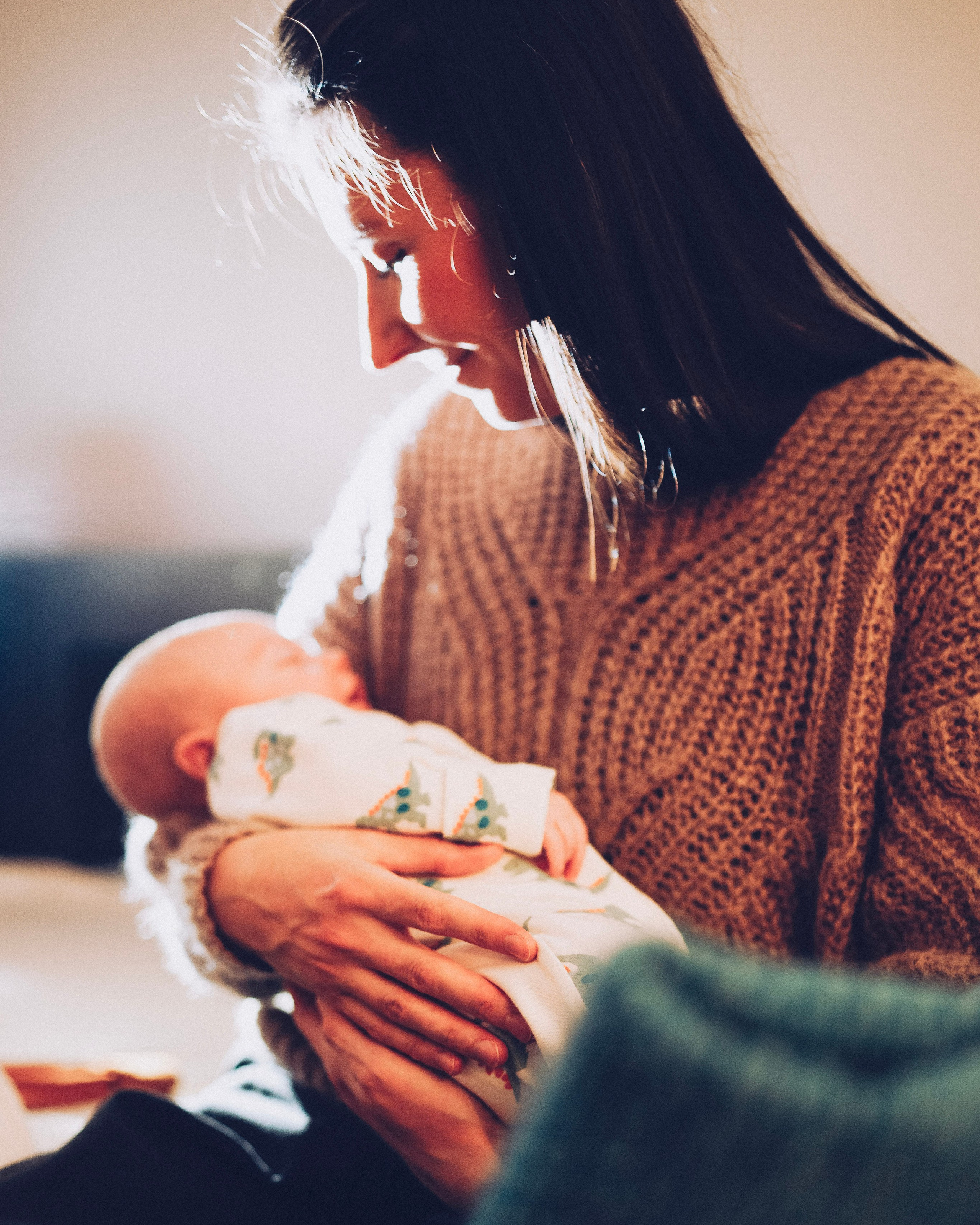 Mum is holding baby during newborn family shoot. Solihull new born session at home. Baby photoshoot in Solihull.