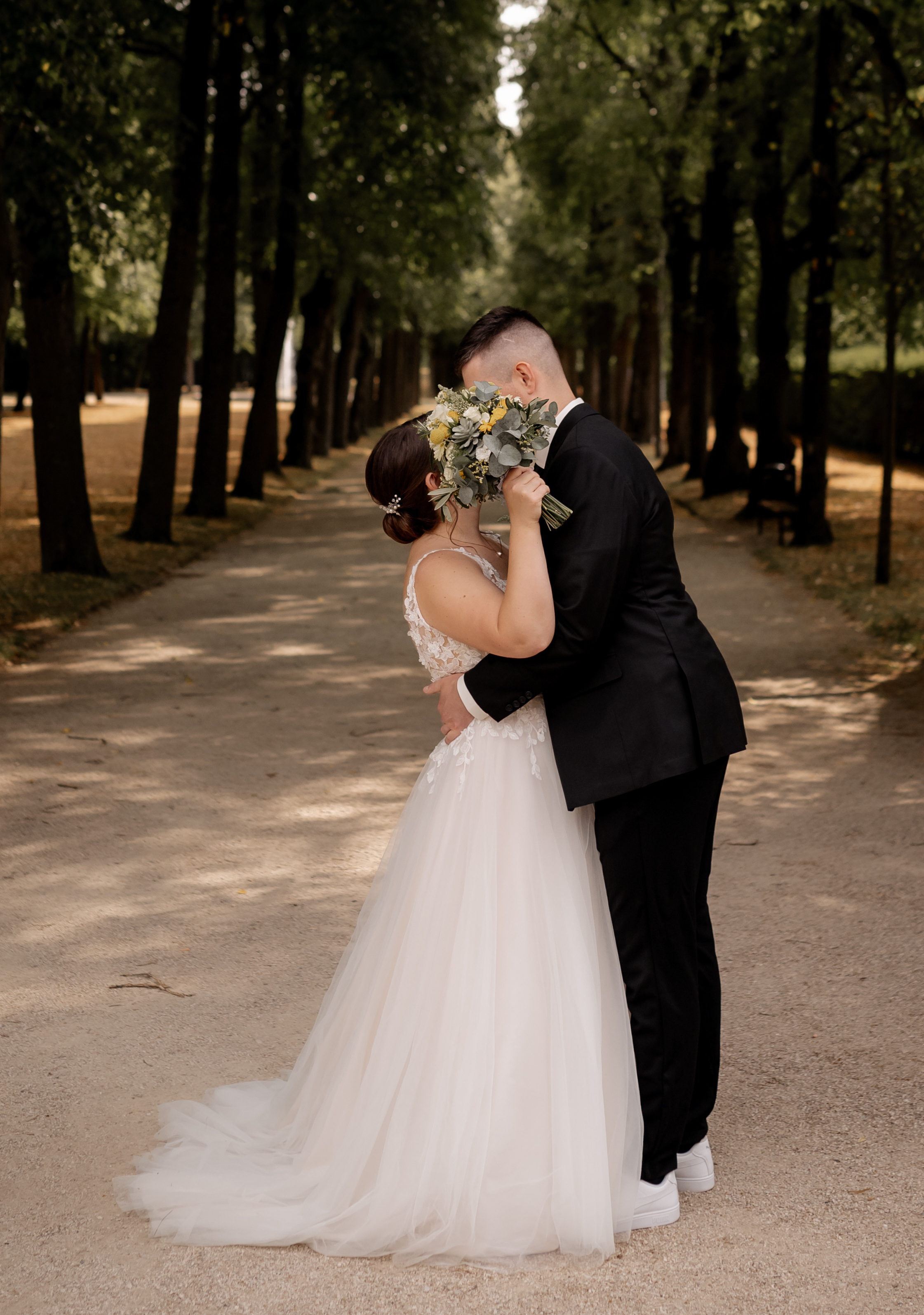 Ein Brautpaar küsst sich im Hofgarten in Ansbach.