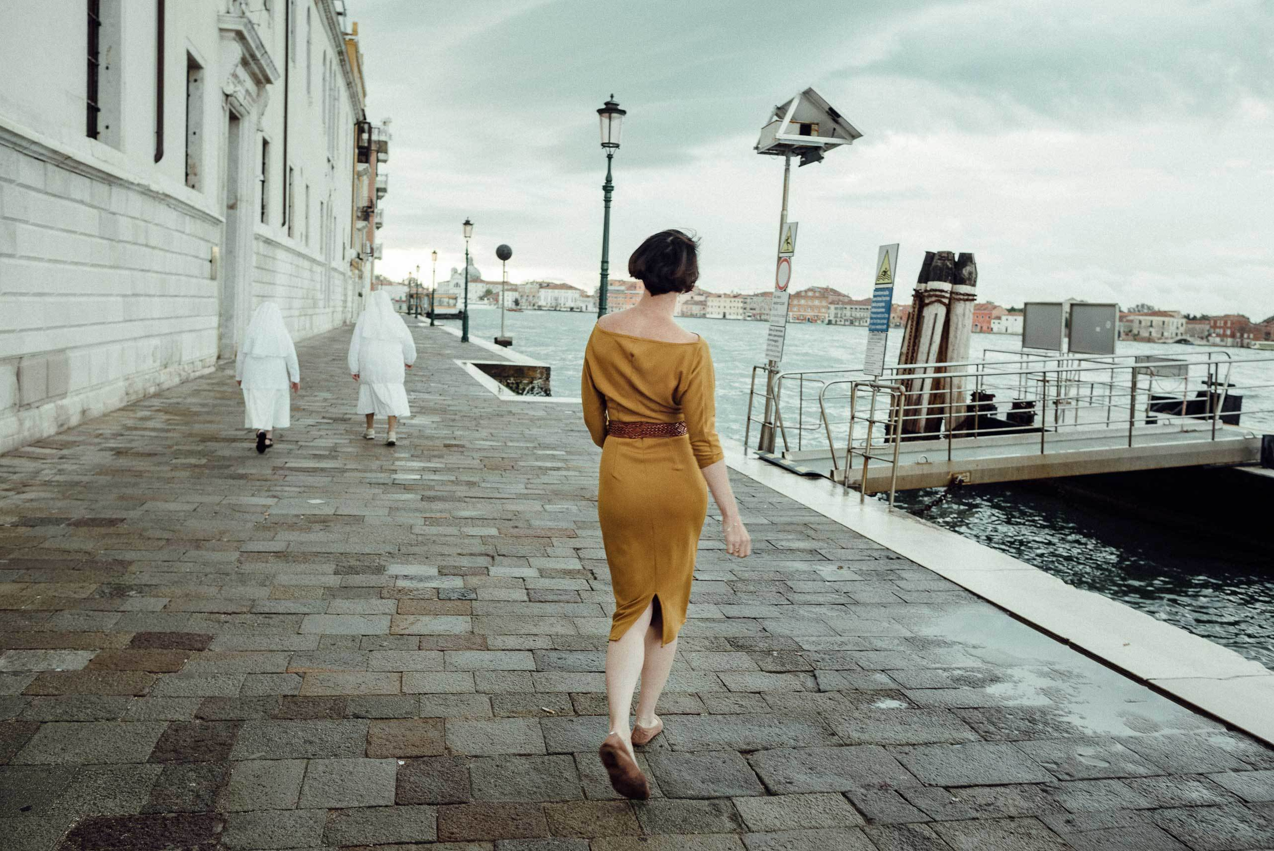 Девушка в желтом платье гуляет по Венеции одна