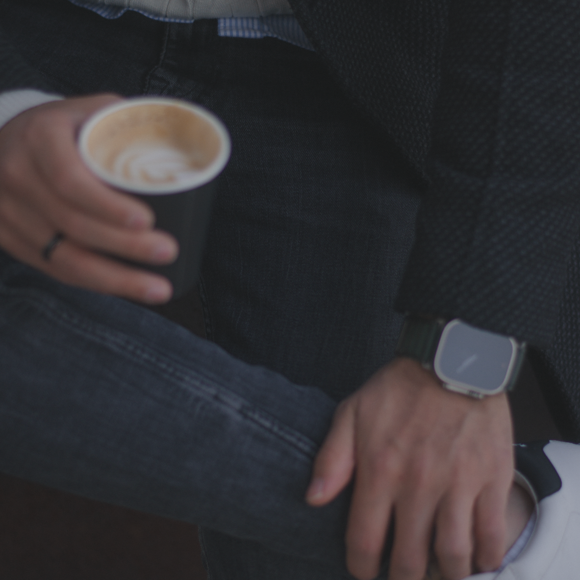 Detail Foto von einem Mann sitzend mit Kaffee und Armbanduhr