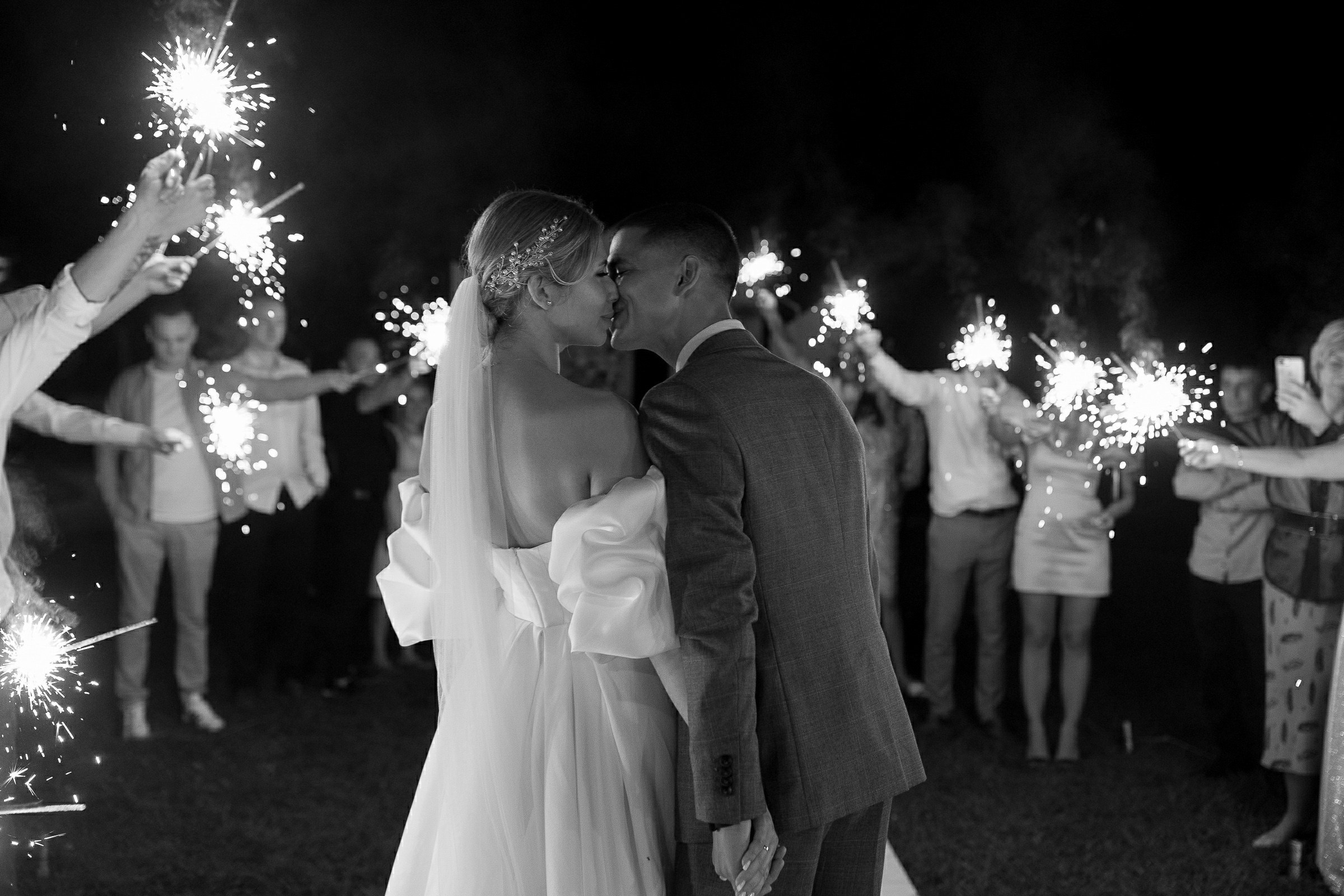Couple’s evening kiss with sparklers, by Bude wedding photographer.