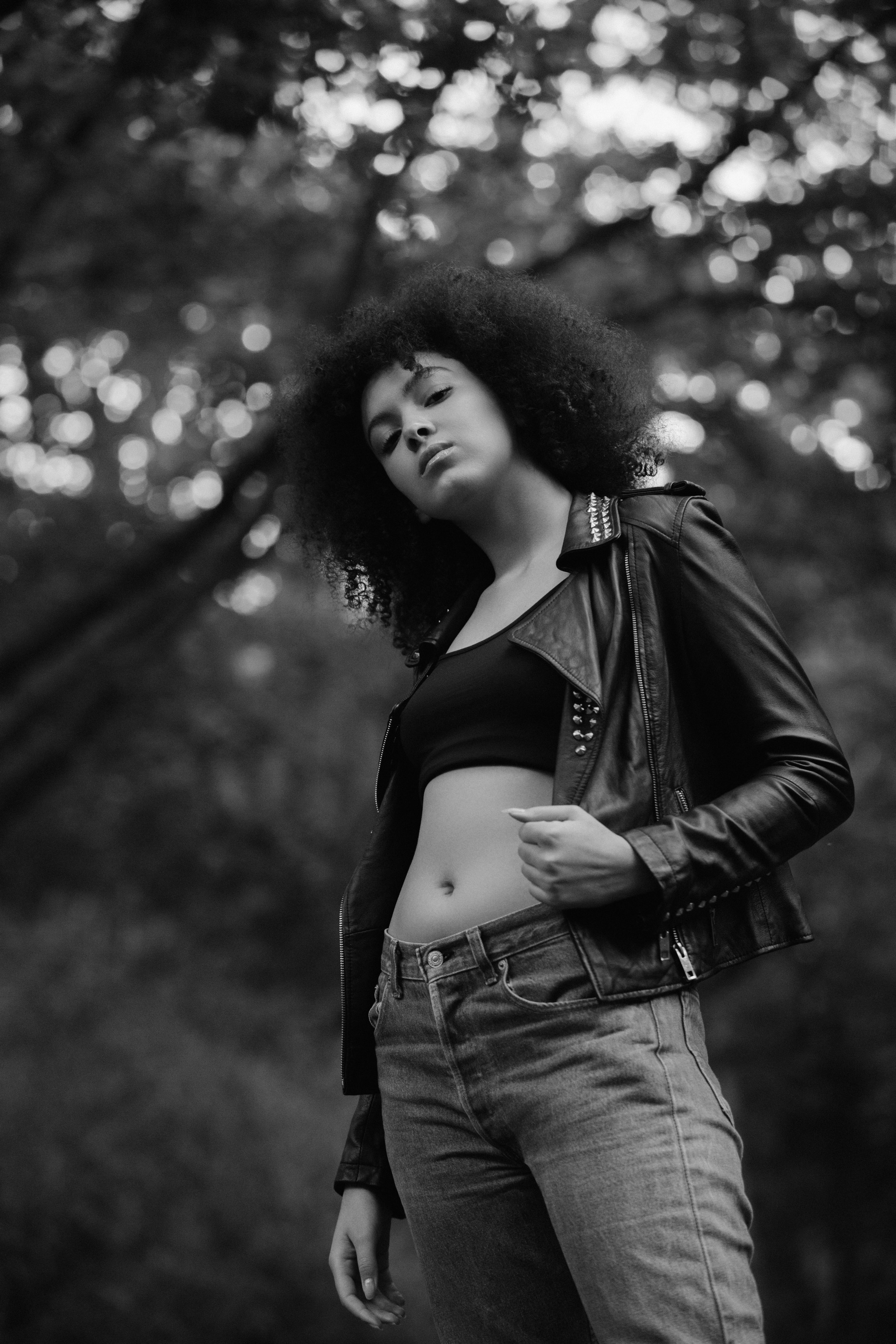 Fashion portrait in forest, leather jacket and jeans, strong pose