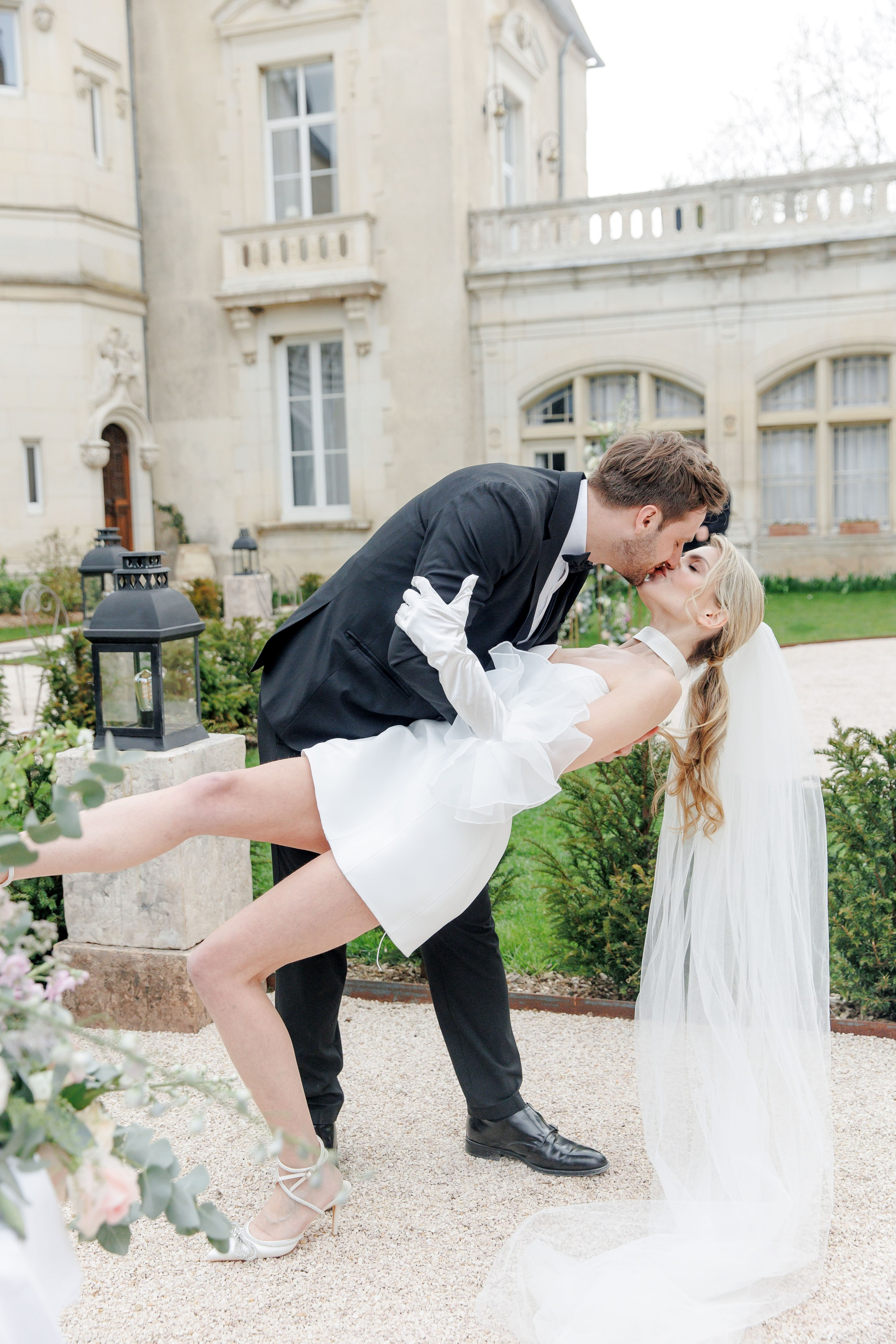 Candid moment of bride and groom kissing during their wedding ceremony in France. 