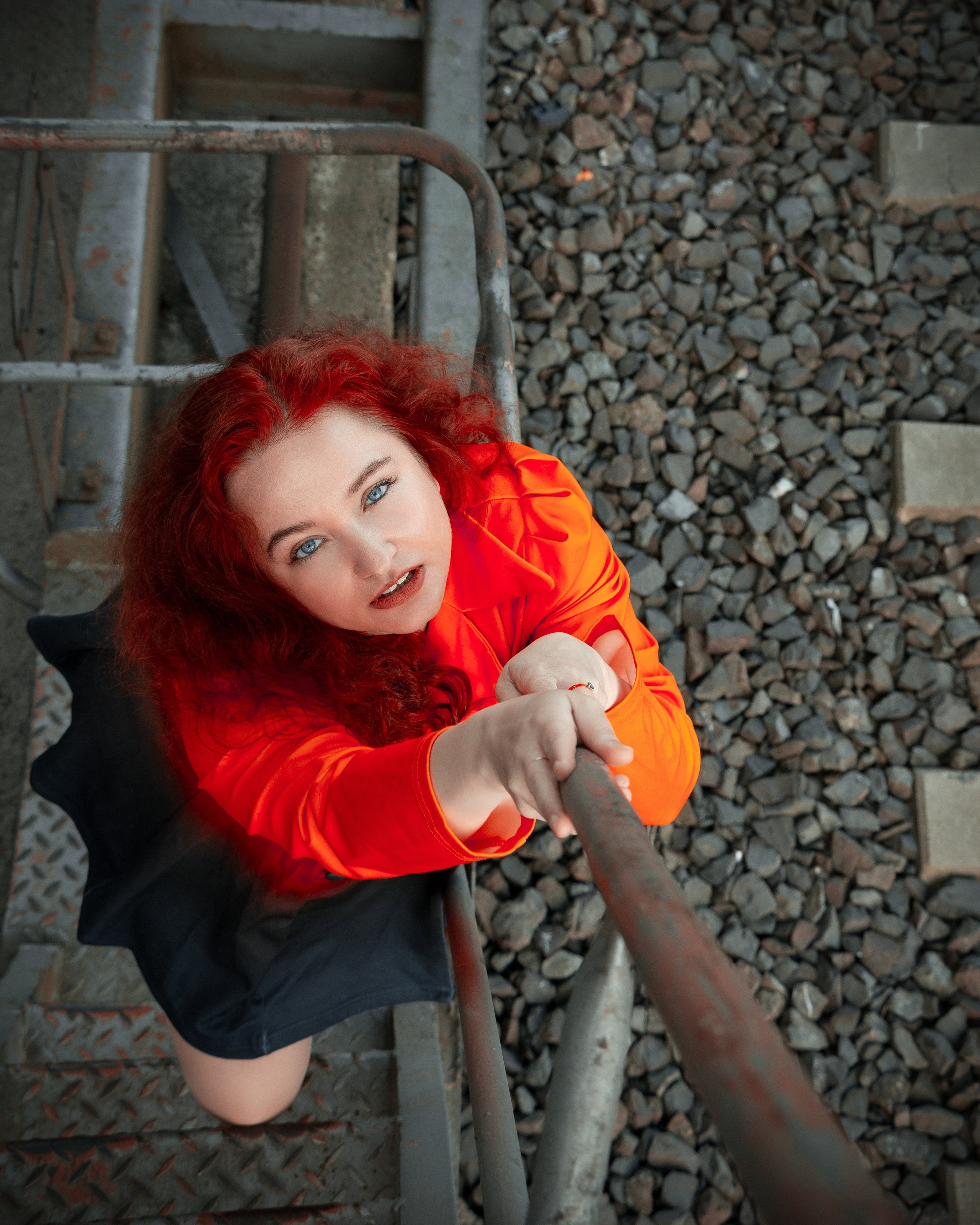 Expressives Porträt einer Frau mit roten Haaren und rotem Kleid im urbanen Umfeld