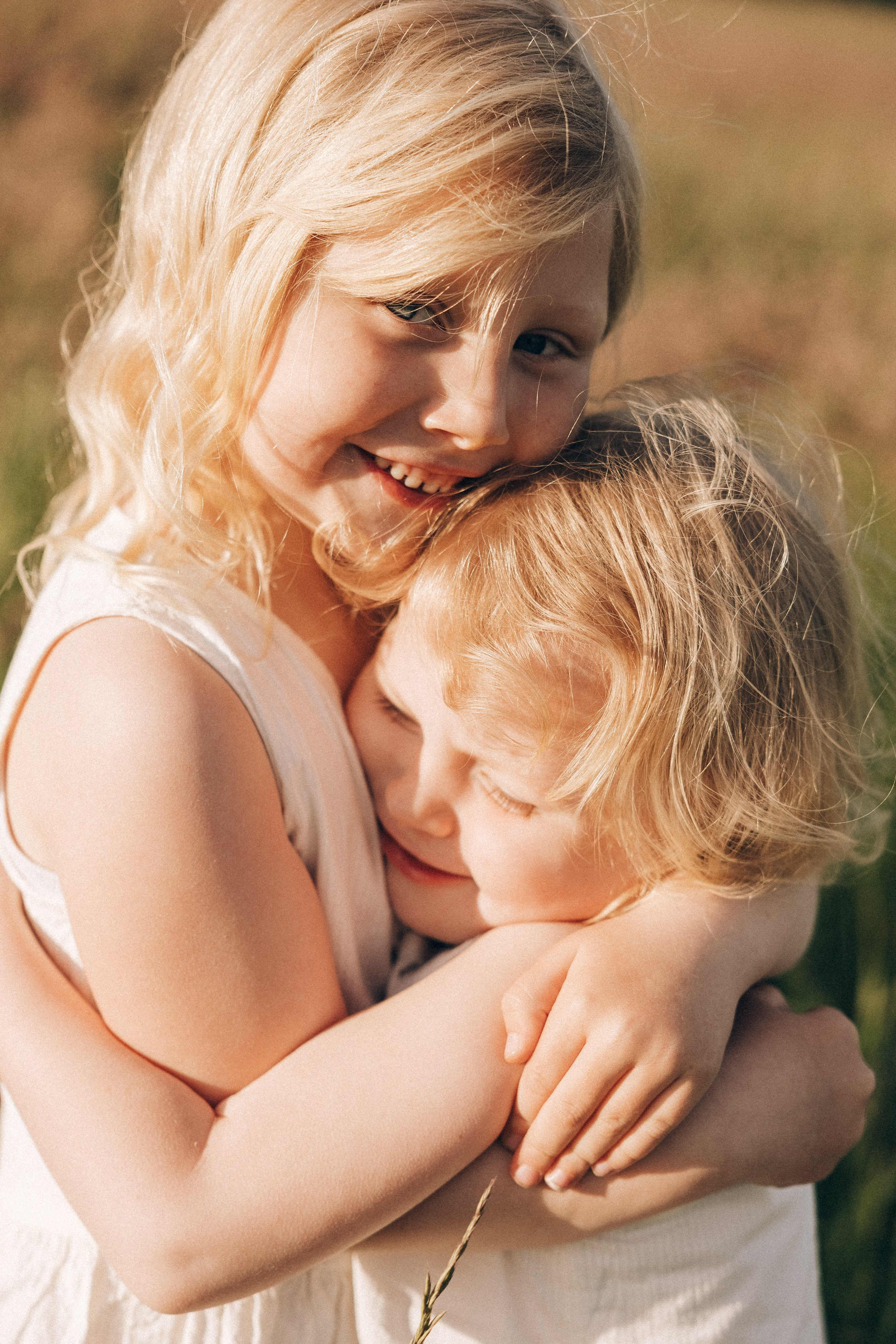 Family photoshoot in a daisy meadow at golden hour — natural light, warm tones, candid moments between a mother and her daughters. Lifestyle and Family Photographer in Pisek Oxana Telupilova