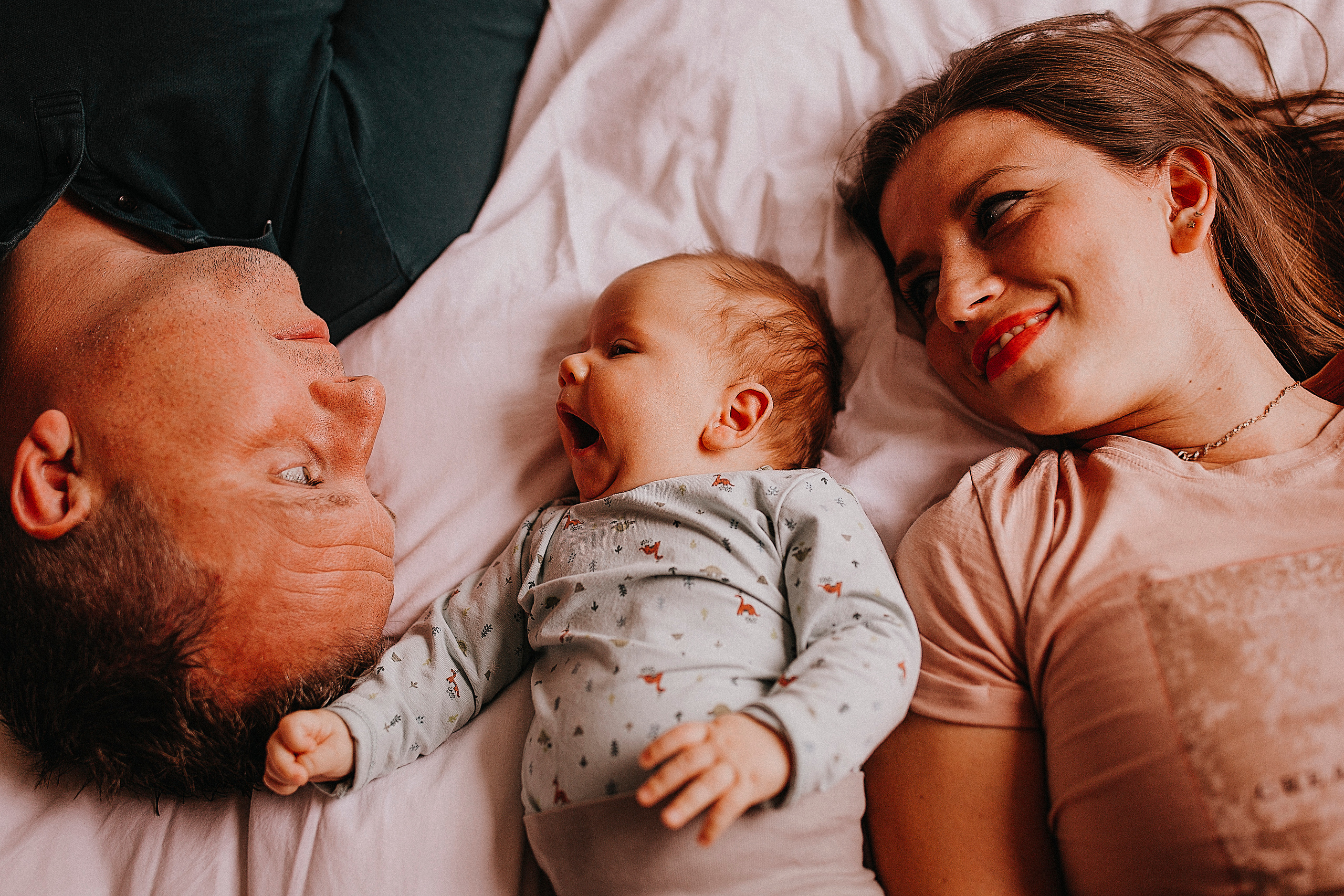  Een knus moment thuis: ouders met hun pasgeboren baby op het bed.