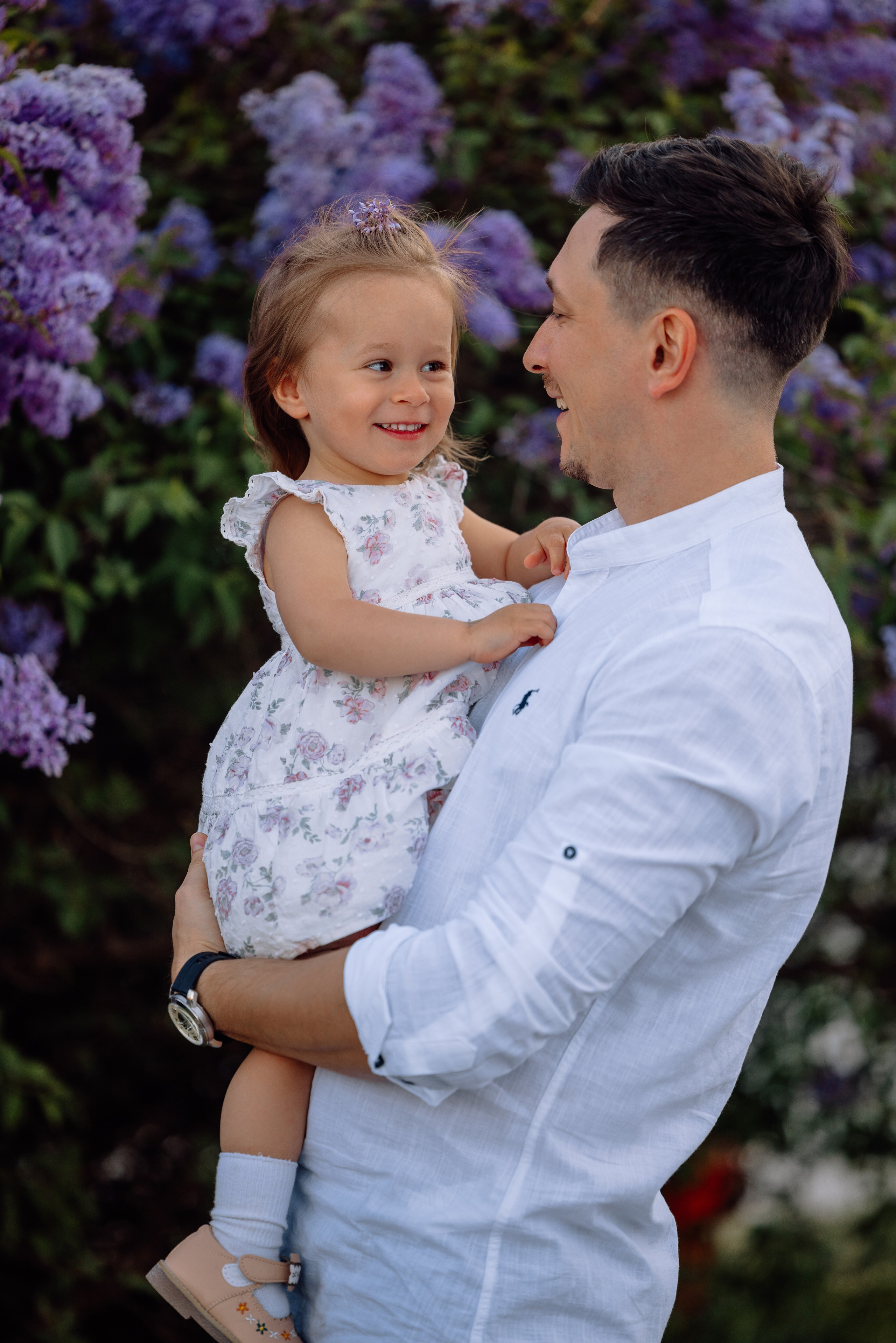 Papa spielt mit Tochter und lacht beim Familienfotoshooting im Schlosspark