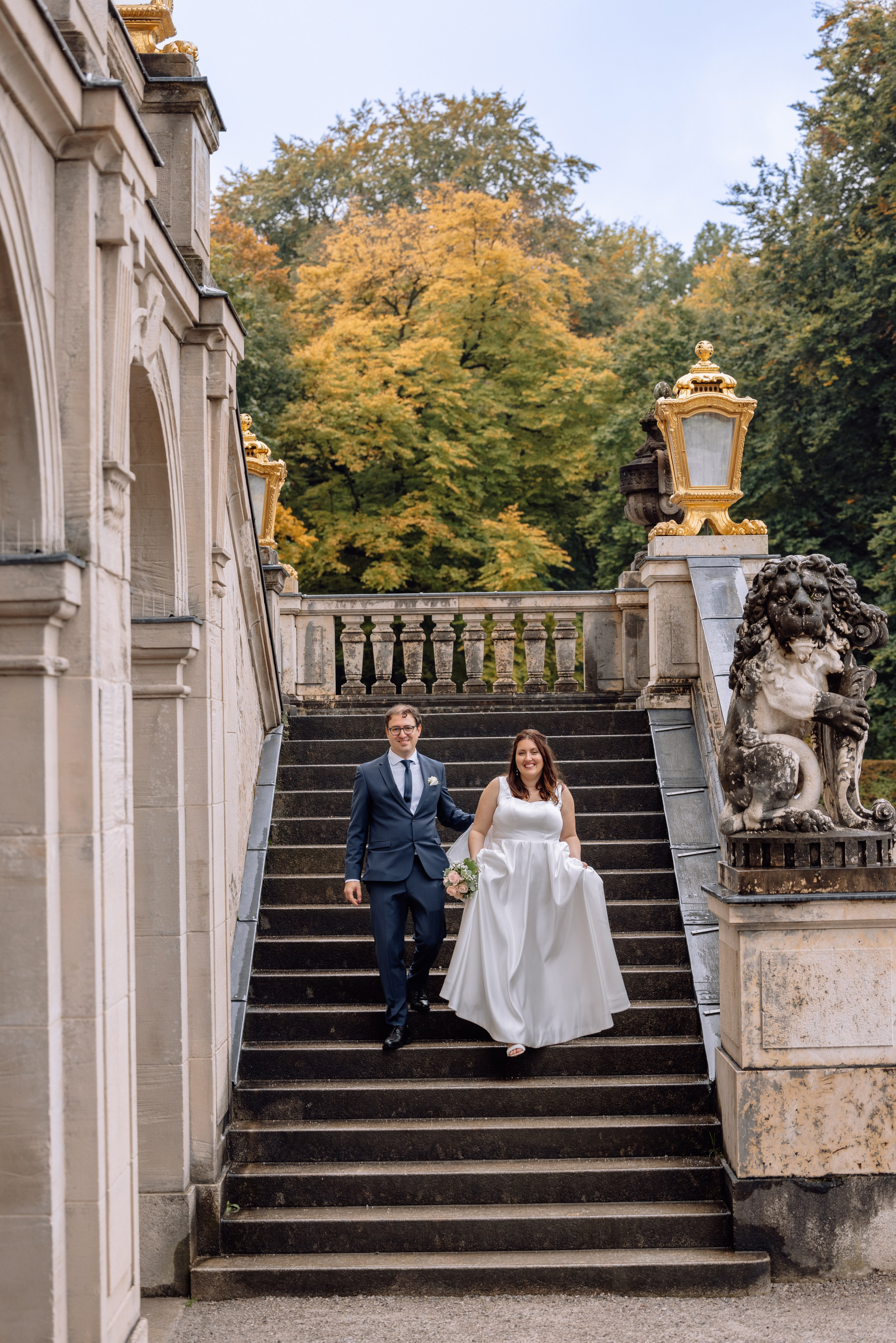 Paar geht die Treppe des Schlosses Nymphenburg in München hinunter