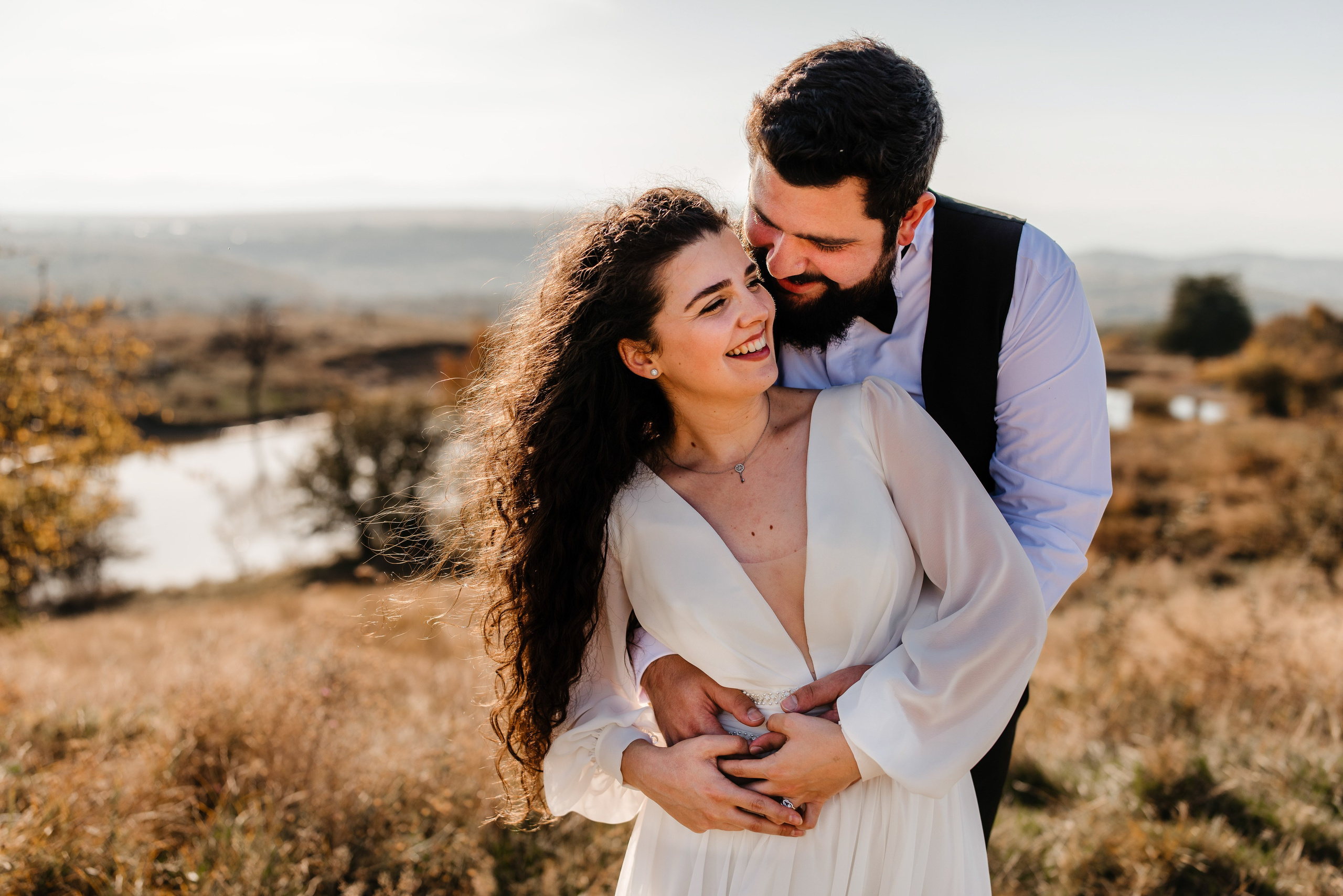 Radu Rahovan Fotograf de nuntă Cluj – mire și mireasă zâmbitori, în sesiune foto la apus, golden hour, lângă un lac pitoresc