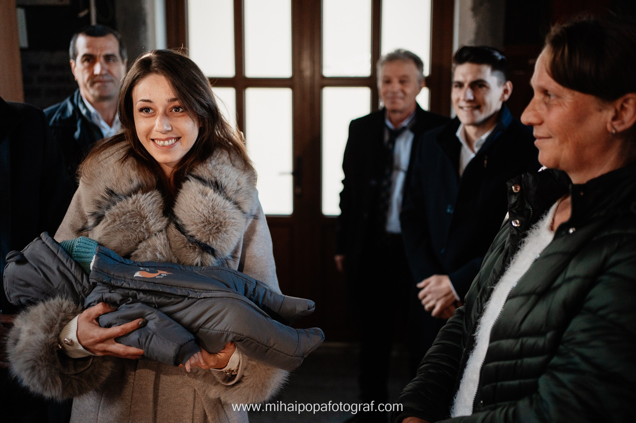 Instantaneu plin de tandrețe dintre părinți și bebeluș în ziua botezului, realizat în ilfov. Fotografie profesională de botez, capturând emoțiile autentice ale familiei într-un decor luminos și cald