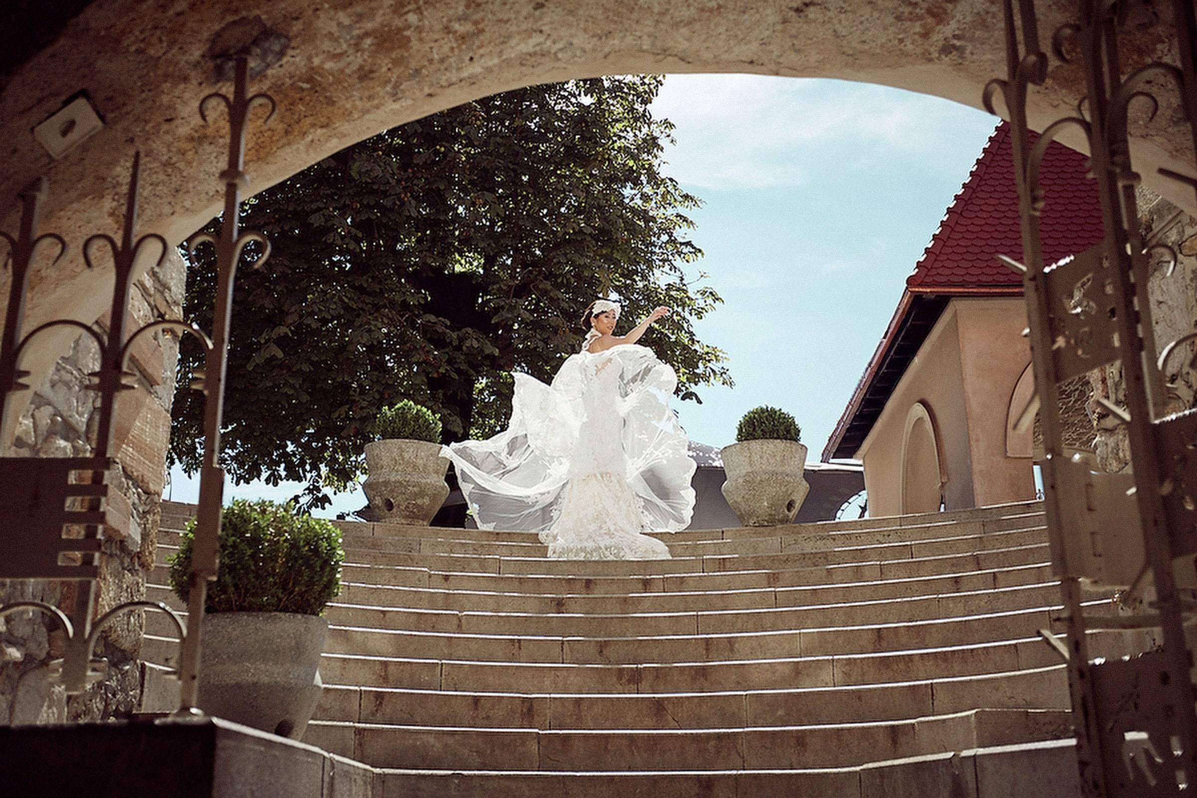 Bride adjusting her dress in the historic courtyard of Castle Bled.