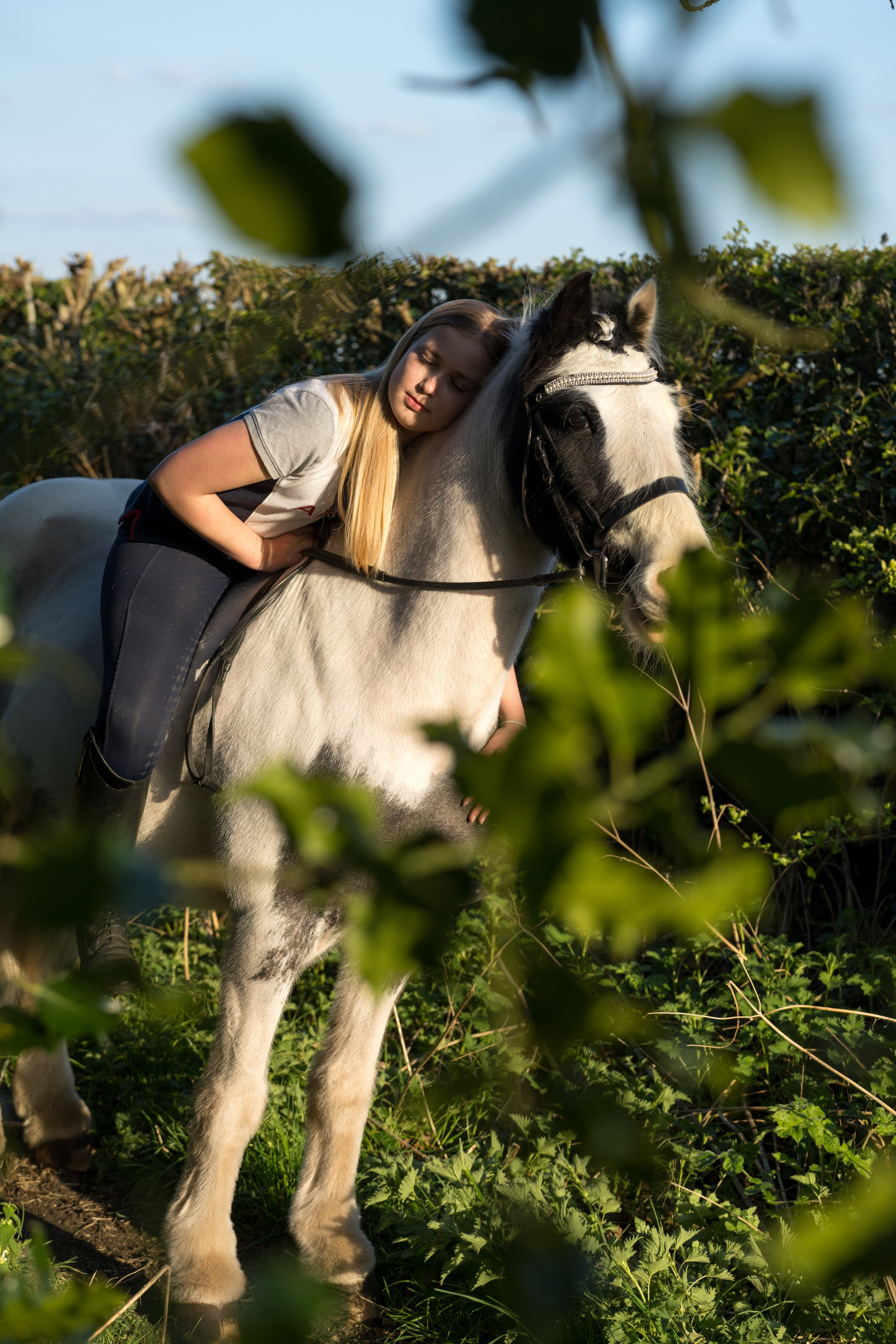 Natural interaction between teenage girl and her horse in open pasture