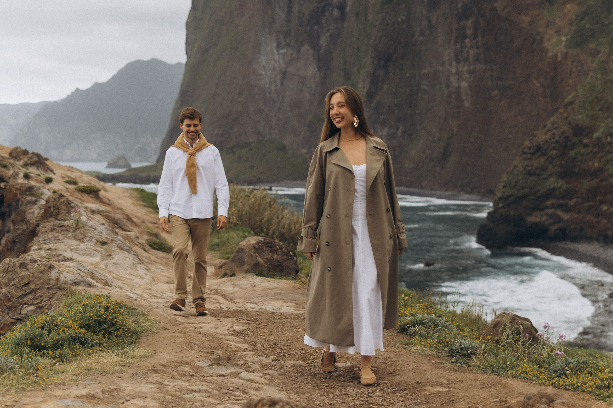 Beautiful engagement moment by the ocean in Madeira, Portugal, as one partner kneels to propose while waves crash in the background
