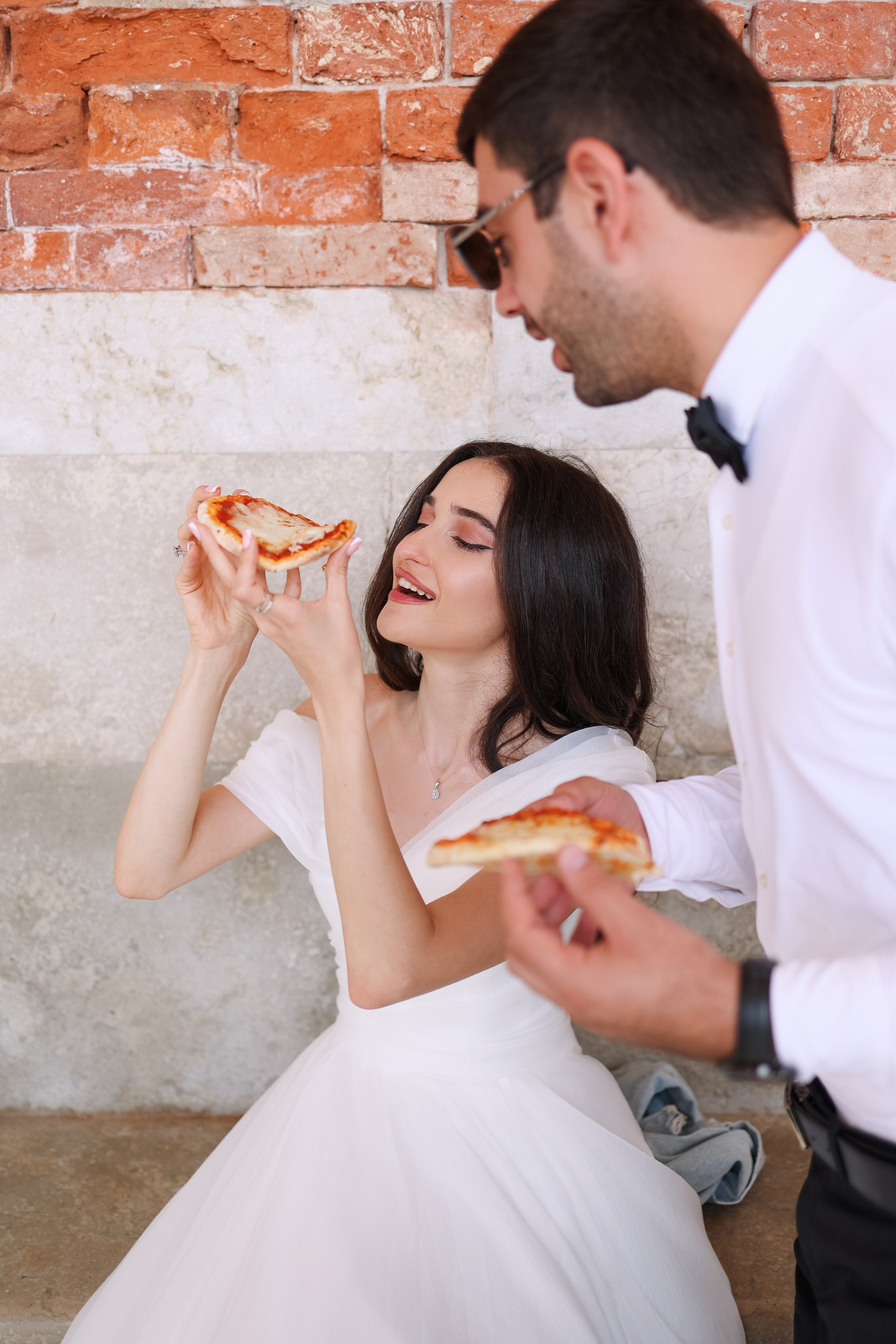 couple eating pizza at wedding day