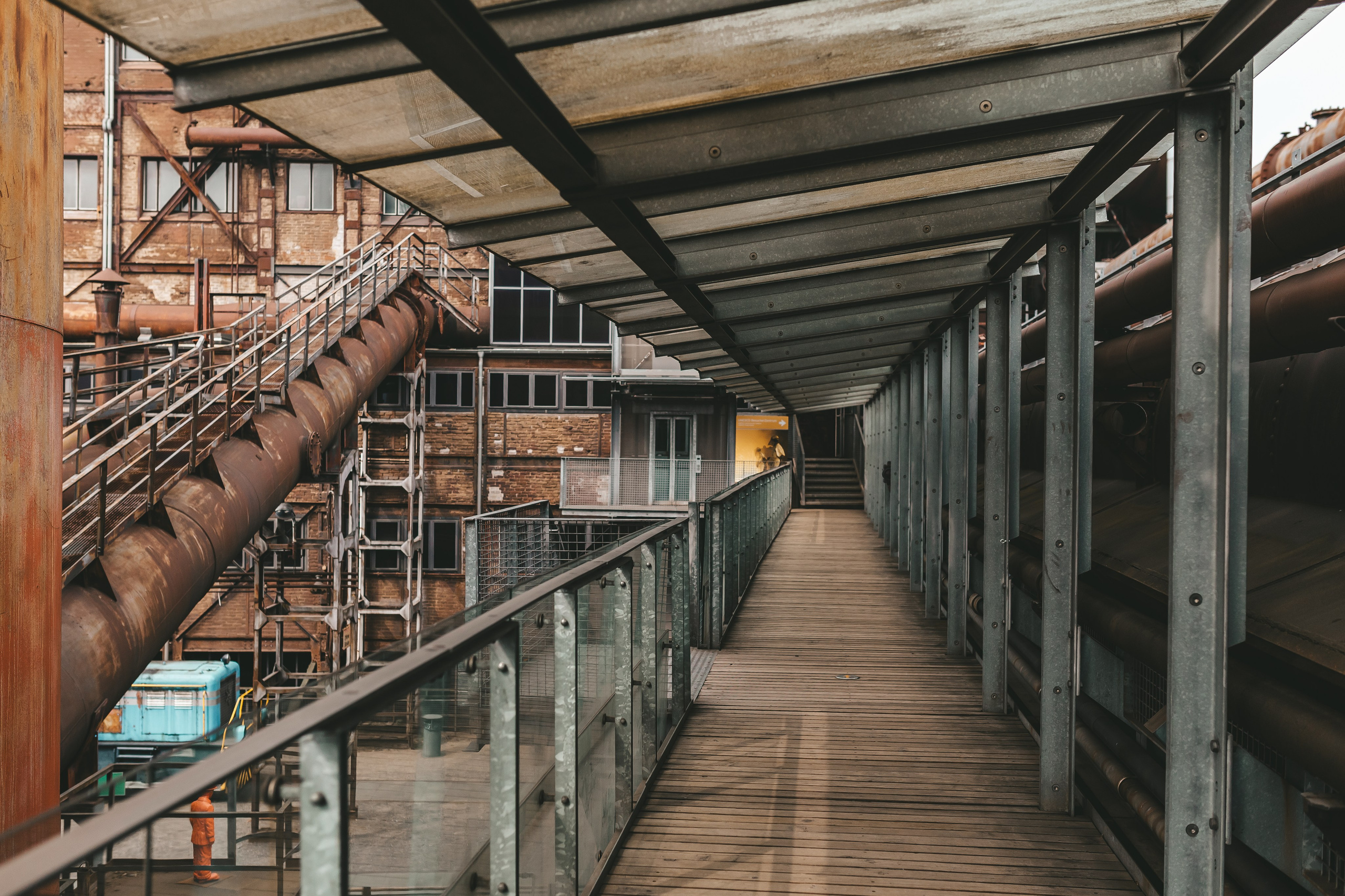 Узкий проход между кирпичными и металлическими стенами завода.