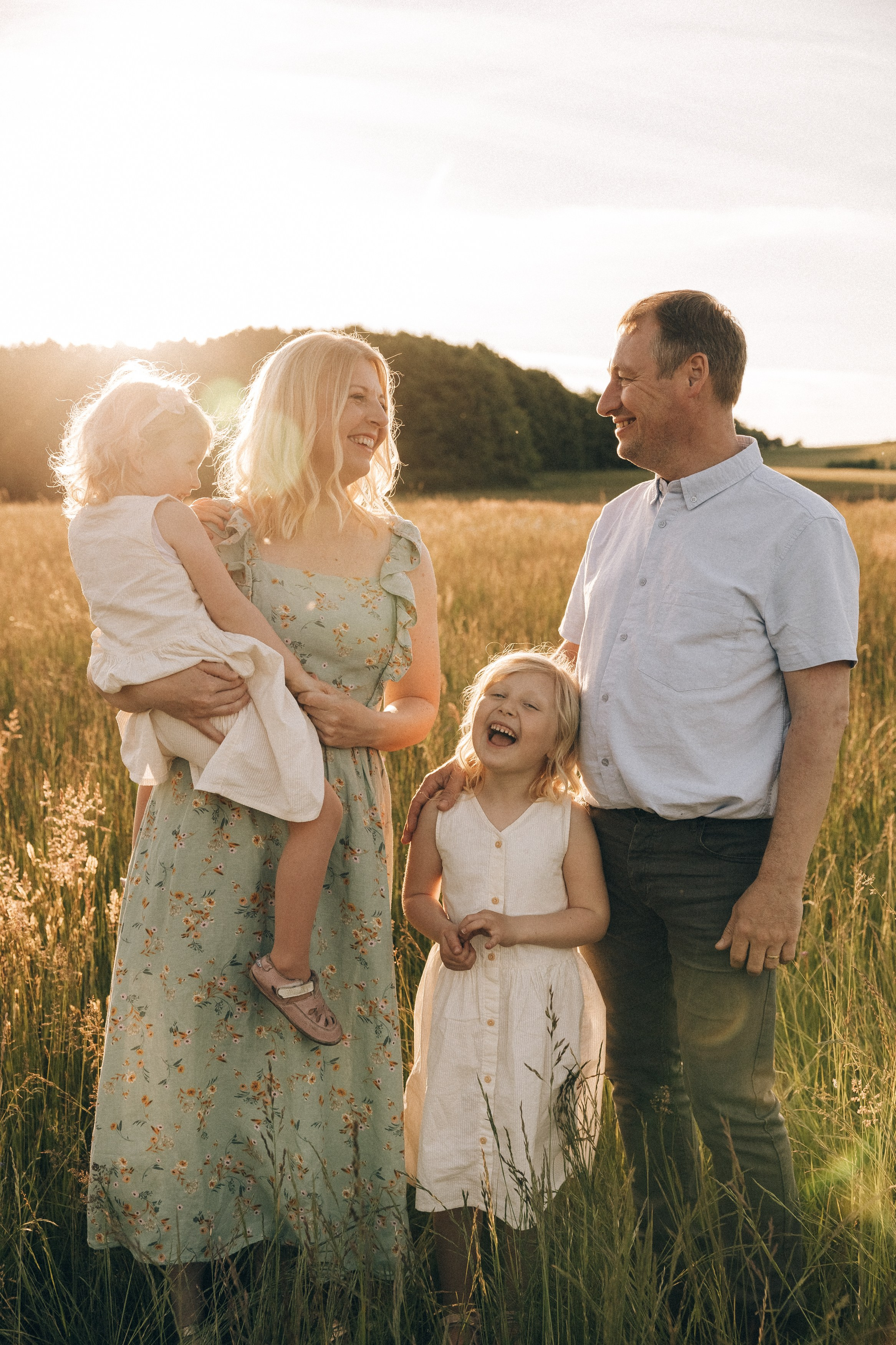 Family photoshoot in a daisy meadow at golden hour — natural light, warm tones, candid moments between a mother and her daughters. Lifestyle and Family Photographer in Pisek Oxana Telupilova