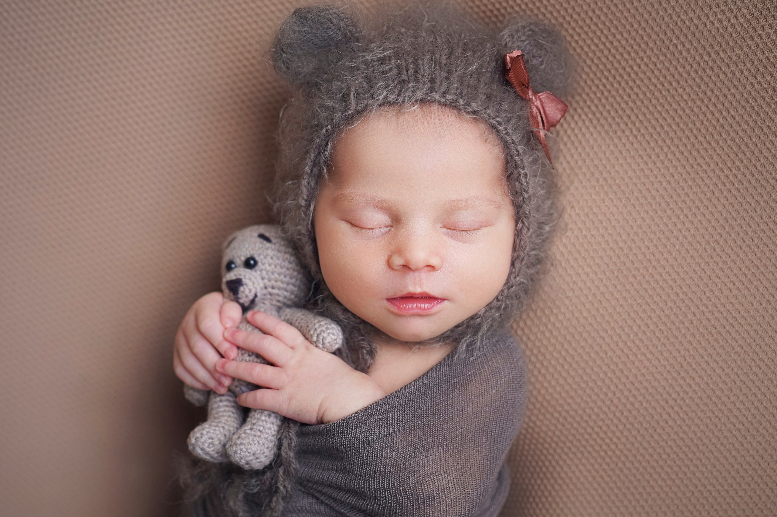 Newborn baby girl with teddy bear in cozy setting
