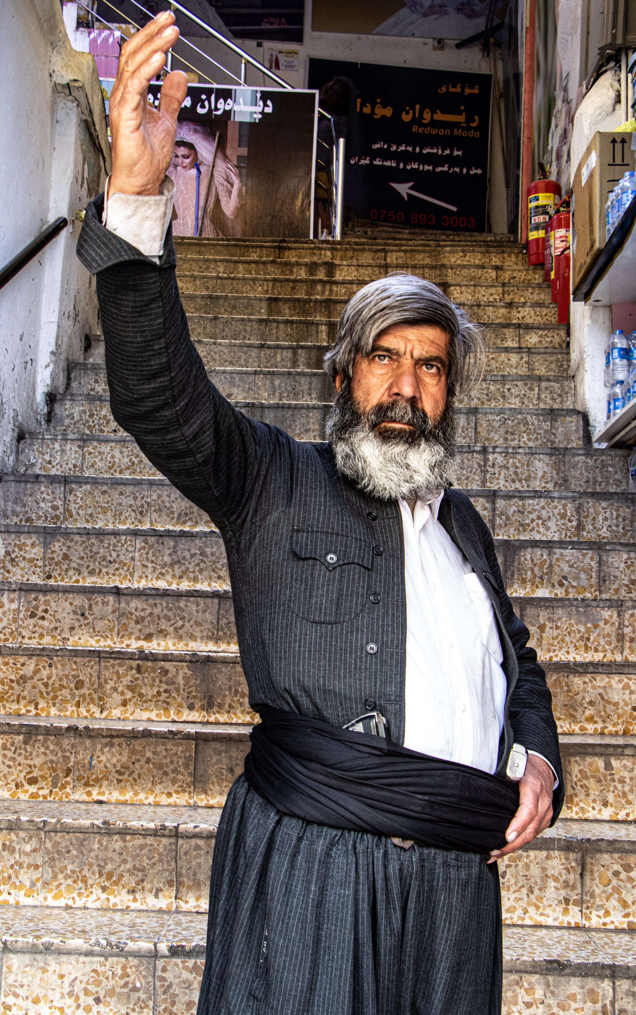 Un ancien combattant peshmerga, armé de pistolets à la ceinture, marche à Erbil.