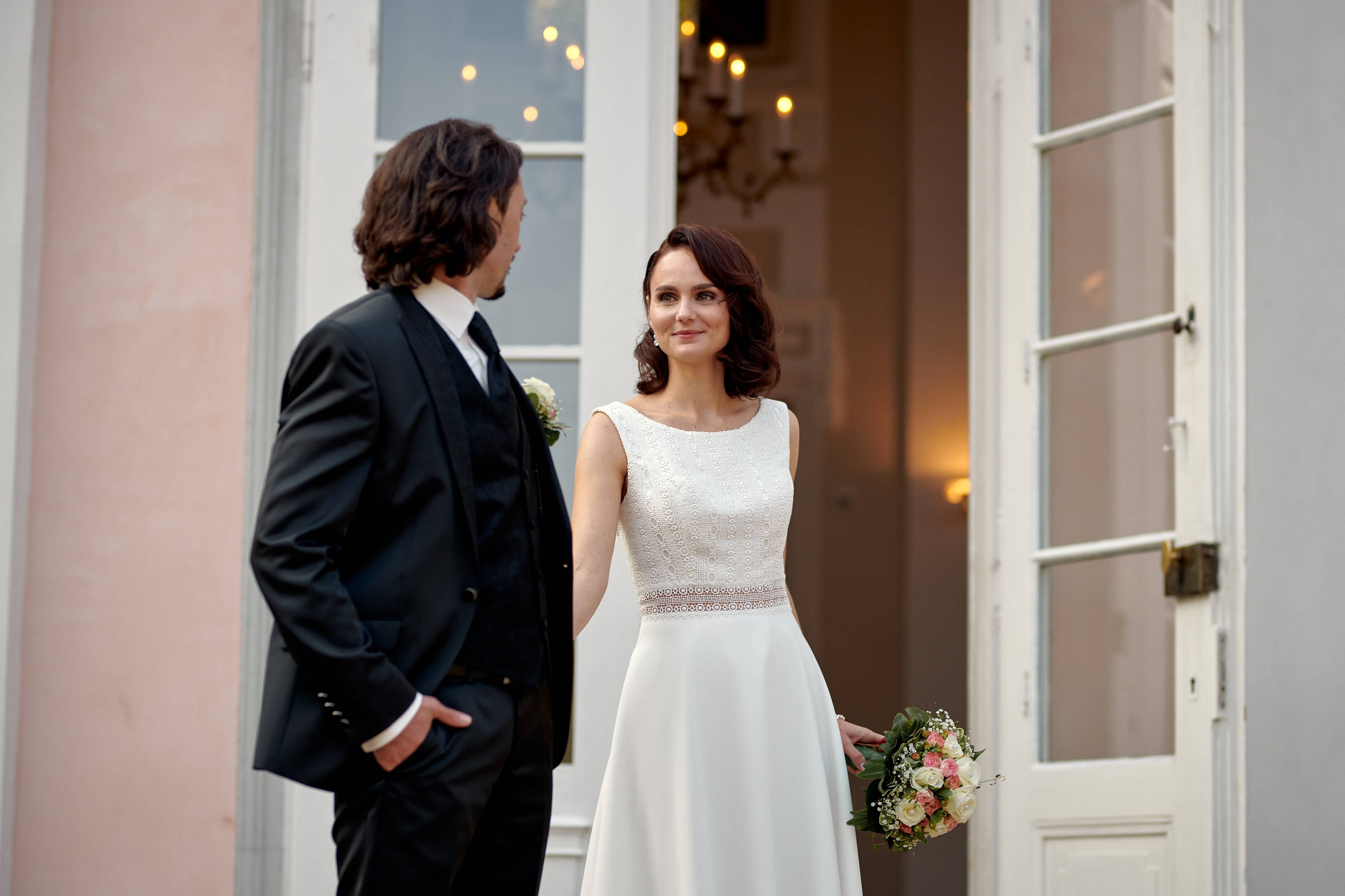 Katja steht mit Brautstrauß an der Tür der Villa Eugenia – ein klassischer, fast filmischer Moment im Eingangsbereich zur standesamtlichen Trauung.