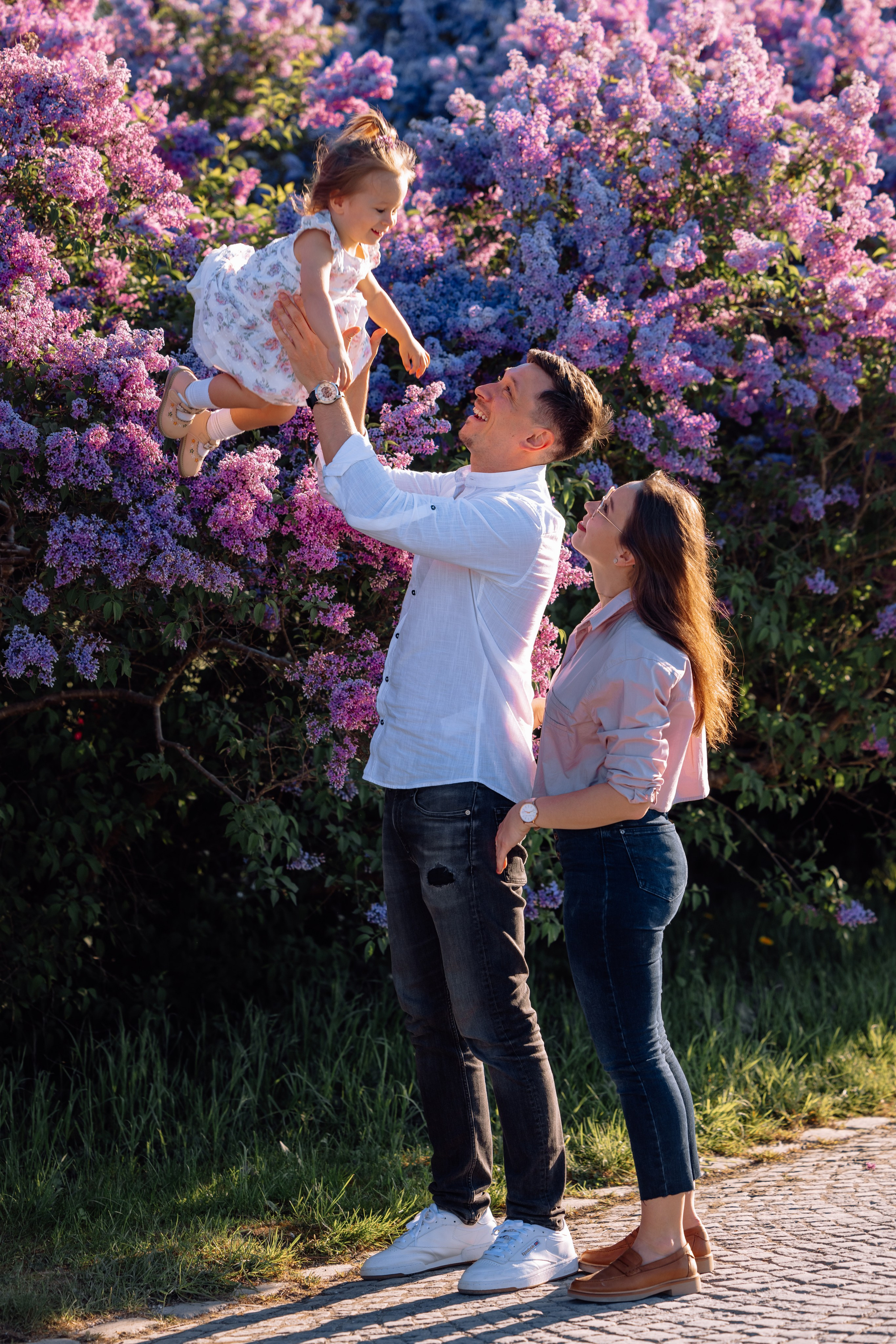 Papa wirft Tochter hoch in die Luft vor dem Schloss Nymphenburg
