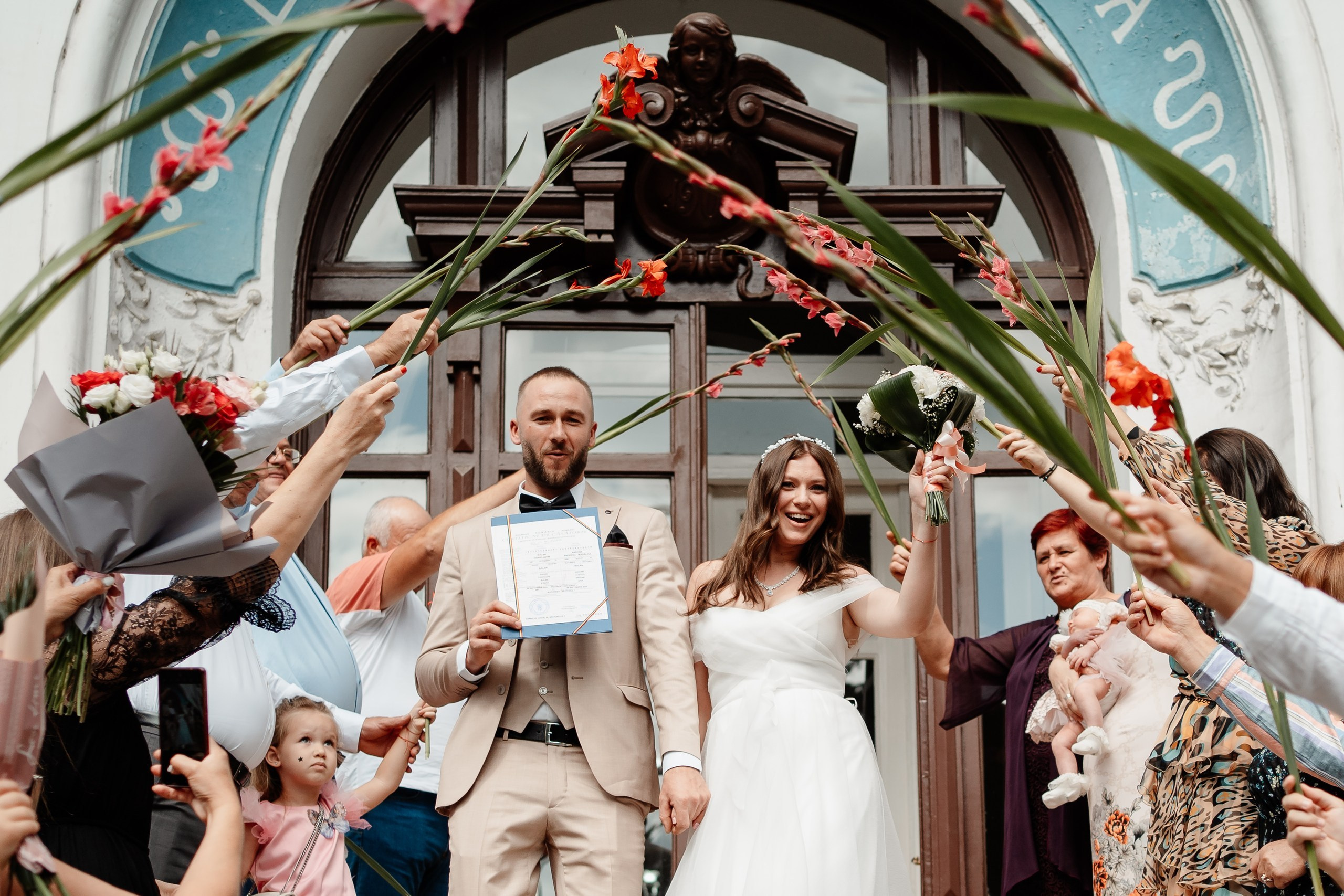 Miri fericiți în fața oficiului stării civile din Bucuresti, Sector 1, celebrând începutul unei noi vieți împreună. Fotografie de cununie civilă, capturând naturalețea și bucuria momentului special.