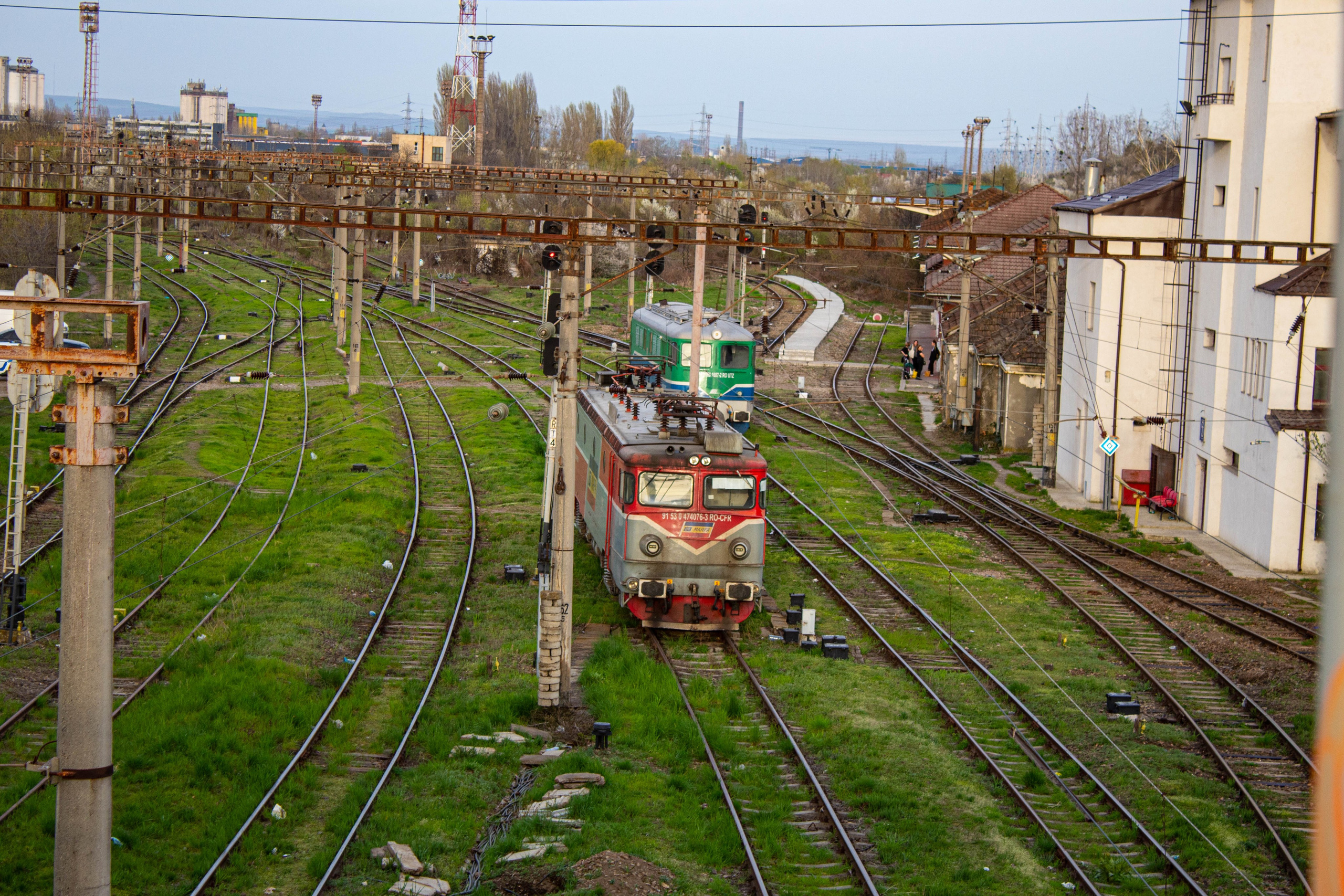 A view of multiple train tracks passing through an urban cityscape in the golden hour.